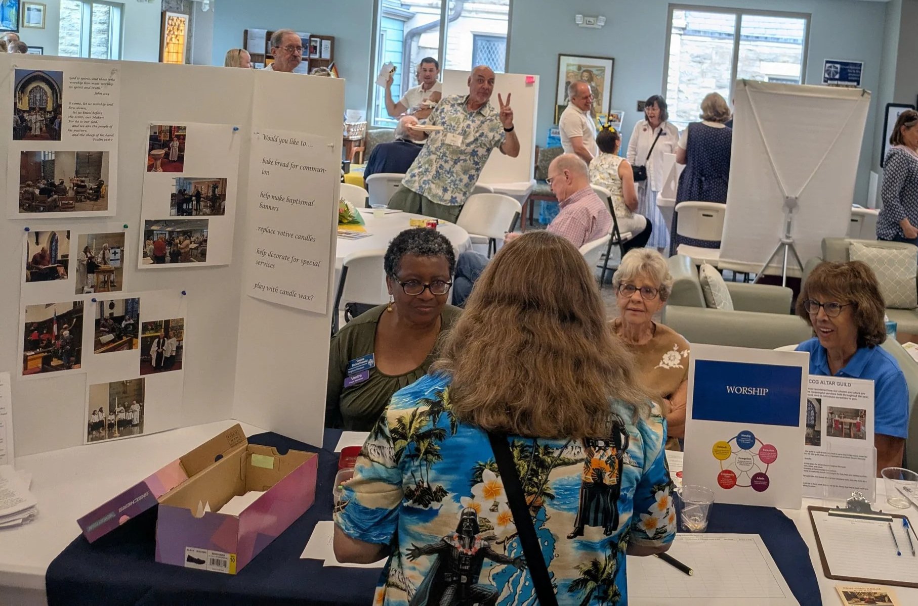 Parishioners gather around display tables and share fellowship during the ministry fair at Christ Church Glendale in Ohio.