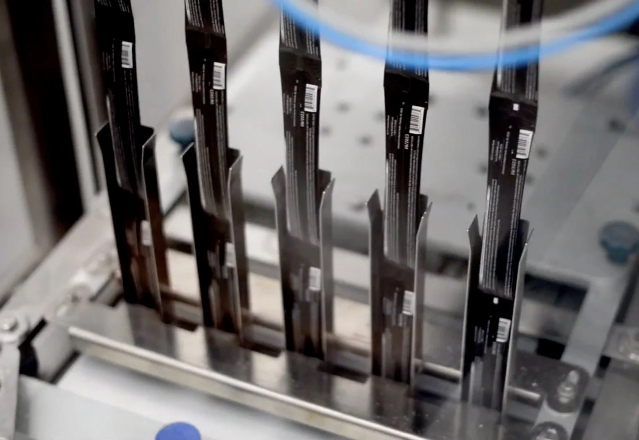Black Stick Packs going through our multi-lane manufacturing machine