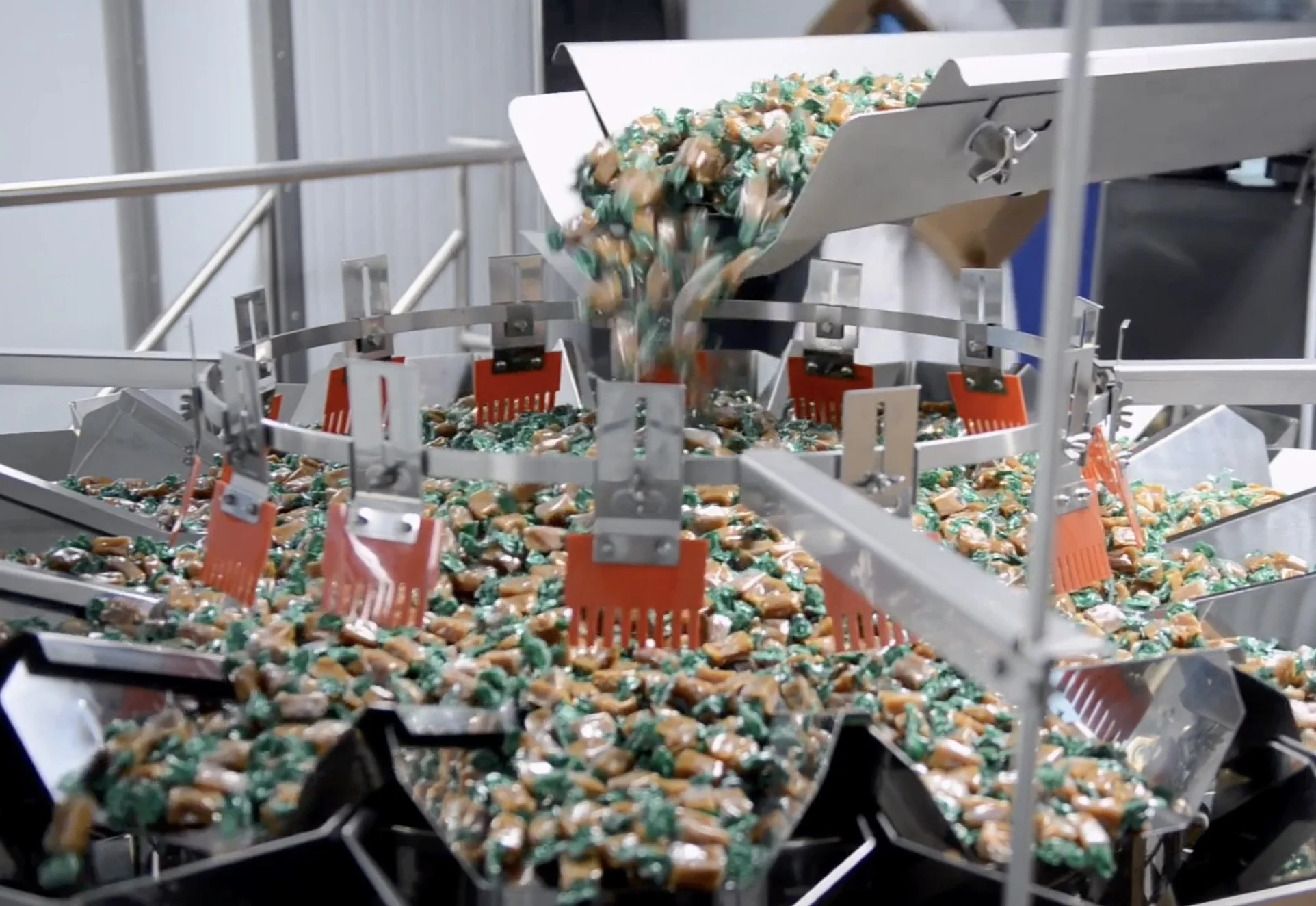 Caramels being sifted into Augers for pouch-filling.
