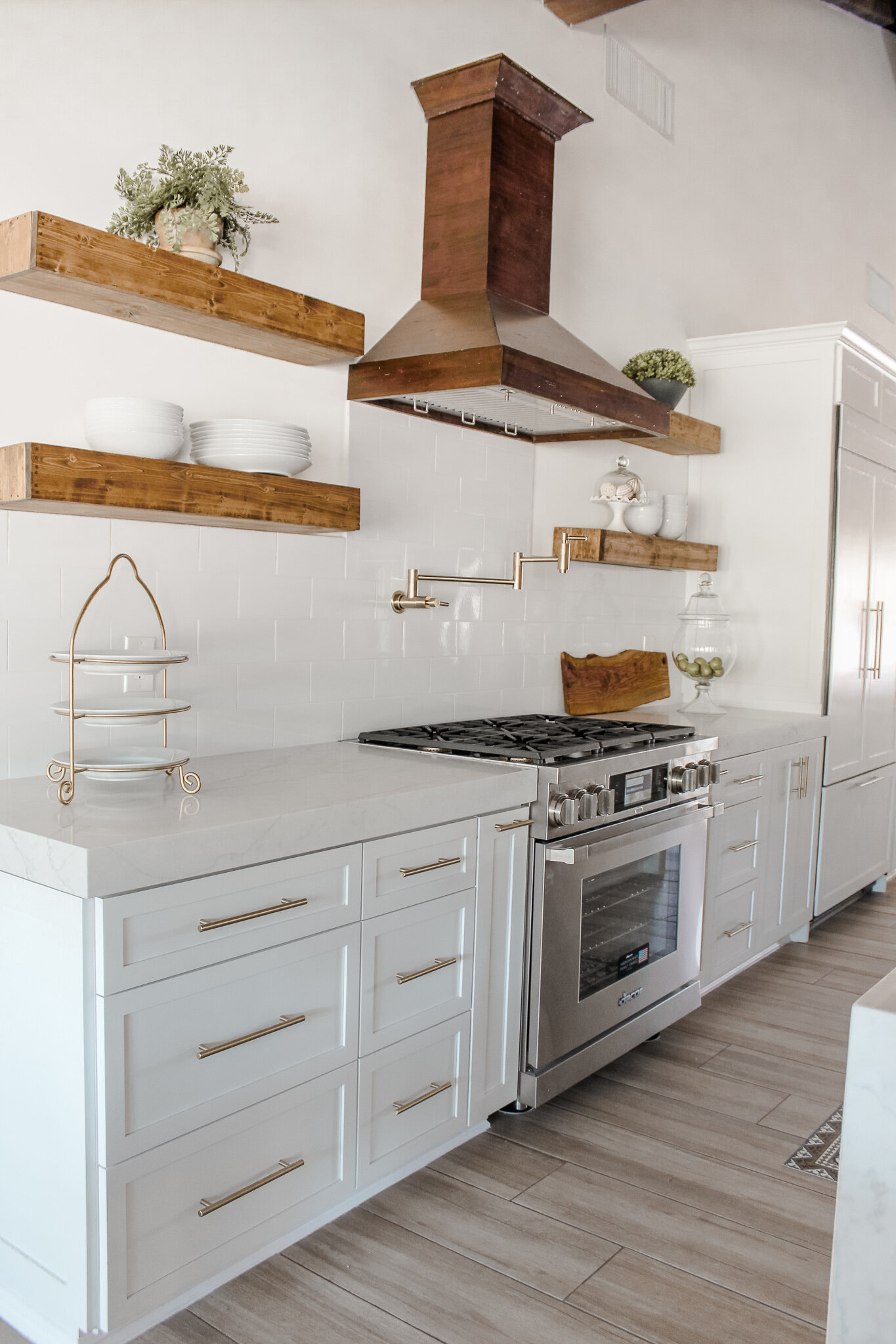 modern farmhouse kitchen floating natural wood shelves white cabinets gold hardware.jpg