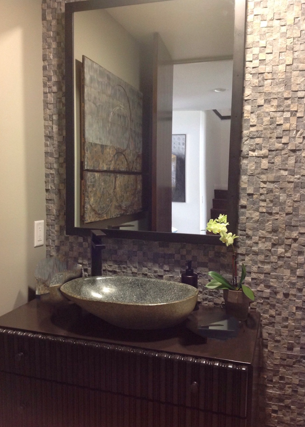  BENEDICT CANYON RESIDENCE  Re-imagined 2 bathrooms from one large. Created an ensuite bathroom and this powder room. Using a found dresser as the vanity with a natural carved stone sink, limestone mosaic tiled wall. Sourced original artwork to tie i