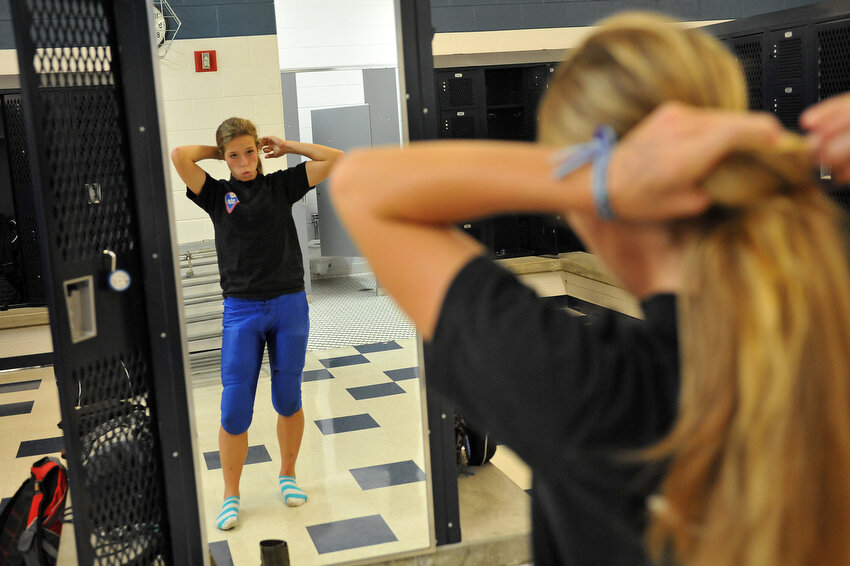  Keara Kilbane ties back her hair in the girl's locker room as she gets ready for football practice Wednesday, Oct. 5, 2011, in Hopkins. Kilbane gets ready in the girl's locker room and meets her teammates in the men's locker room after everyone is d