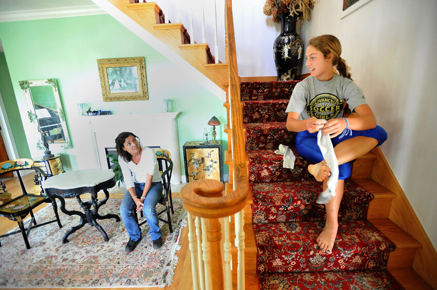  Keara Kilbane puts on her socks and talks to her mom Paula as she gets ready for her game Friday, Oct. 7, 2011, at her home in Hopkins. 