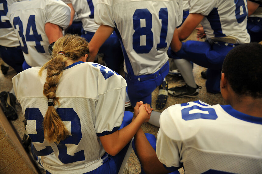  Keara Kilbane, left, holds her teammate's hands as they pray before the game against Calvin Christian Friday, Oct. 7, 2011, in Grandville. 