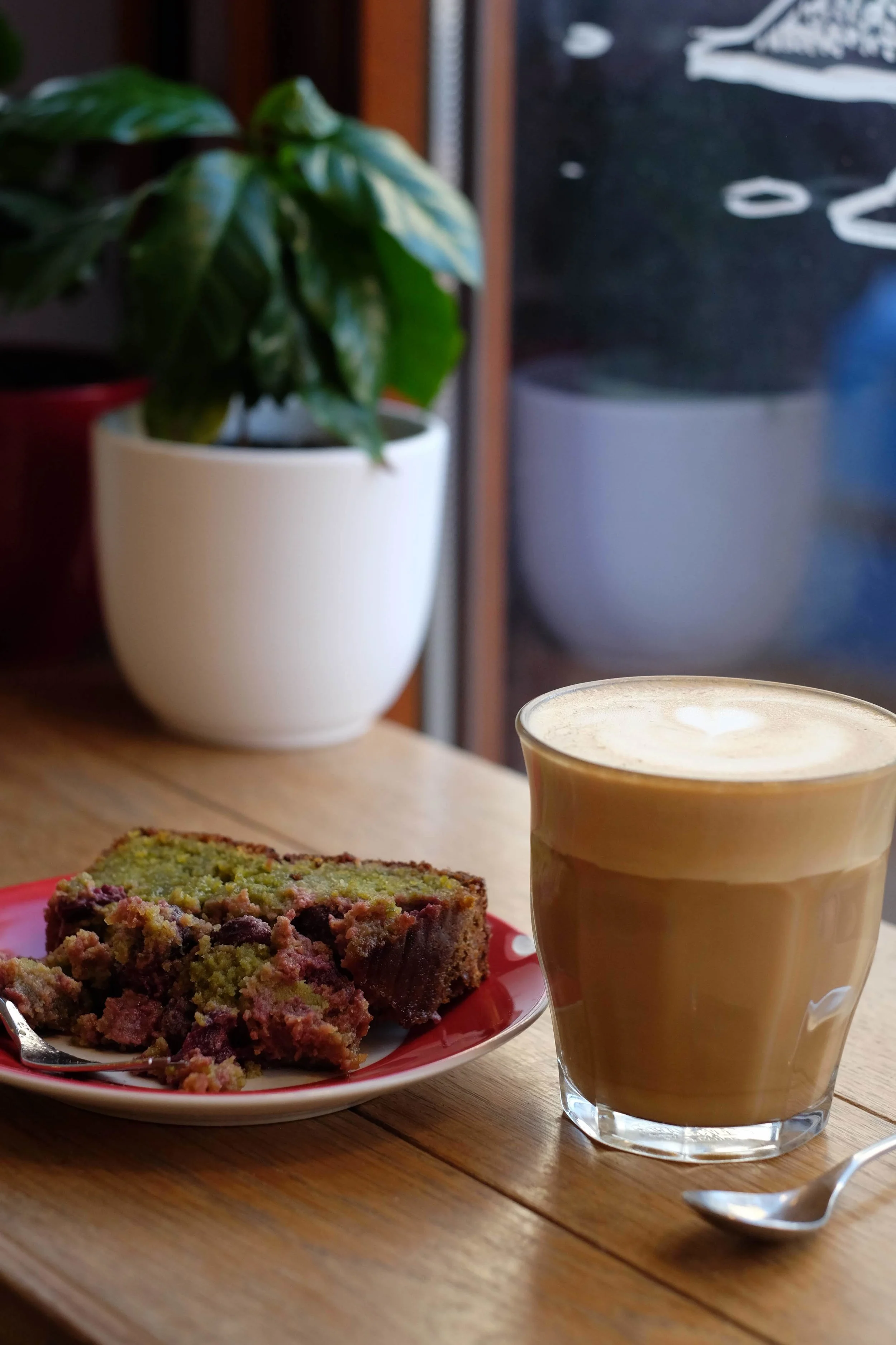 A latté with a slice of pistache griotte bread at Coffee Makers