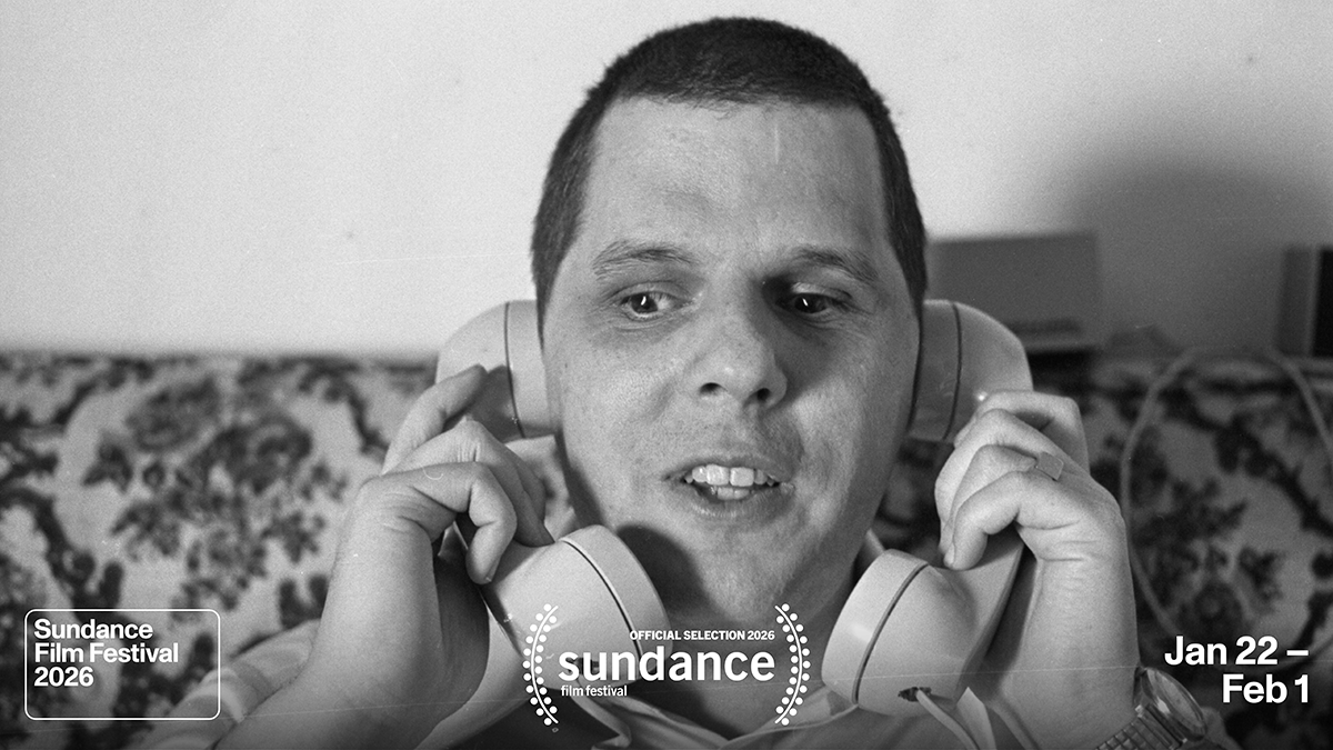 Black and white photo of Joybubbles, a white male with short hair, sitting on a sofa. He is smiling, holding 2 telephone receivers up to each ear. Overlaid are laurels and text "Sundance Film Festival 2026, official selection" dates "Jan 22-Feb 1"
