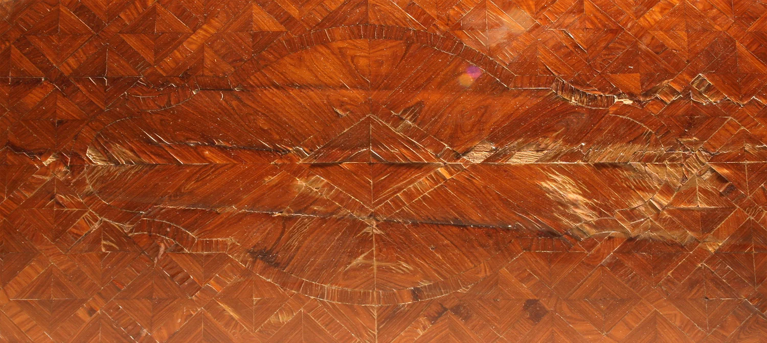 Decorative veneered surface with damage caused by wear, water, and substrate movements