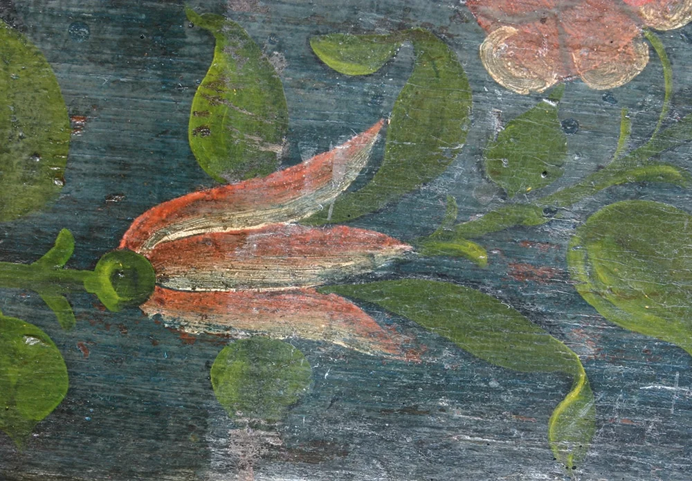 A thin layer of reversible coating (visible on the left) restores the depth of color and contrast to the painted surface of a historic furniture piece. The paint was blanched as a result of exposure to flood water.