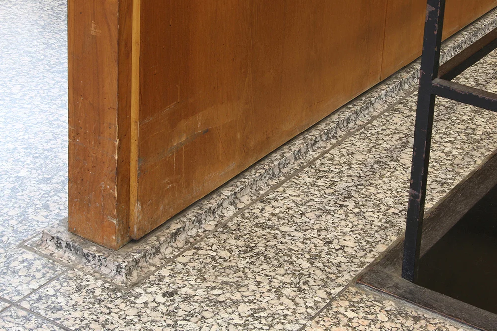 Abrasions and water damage to veneered panels at the floor level | Photo courtesy of GSA