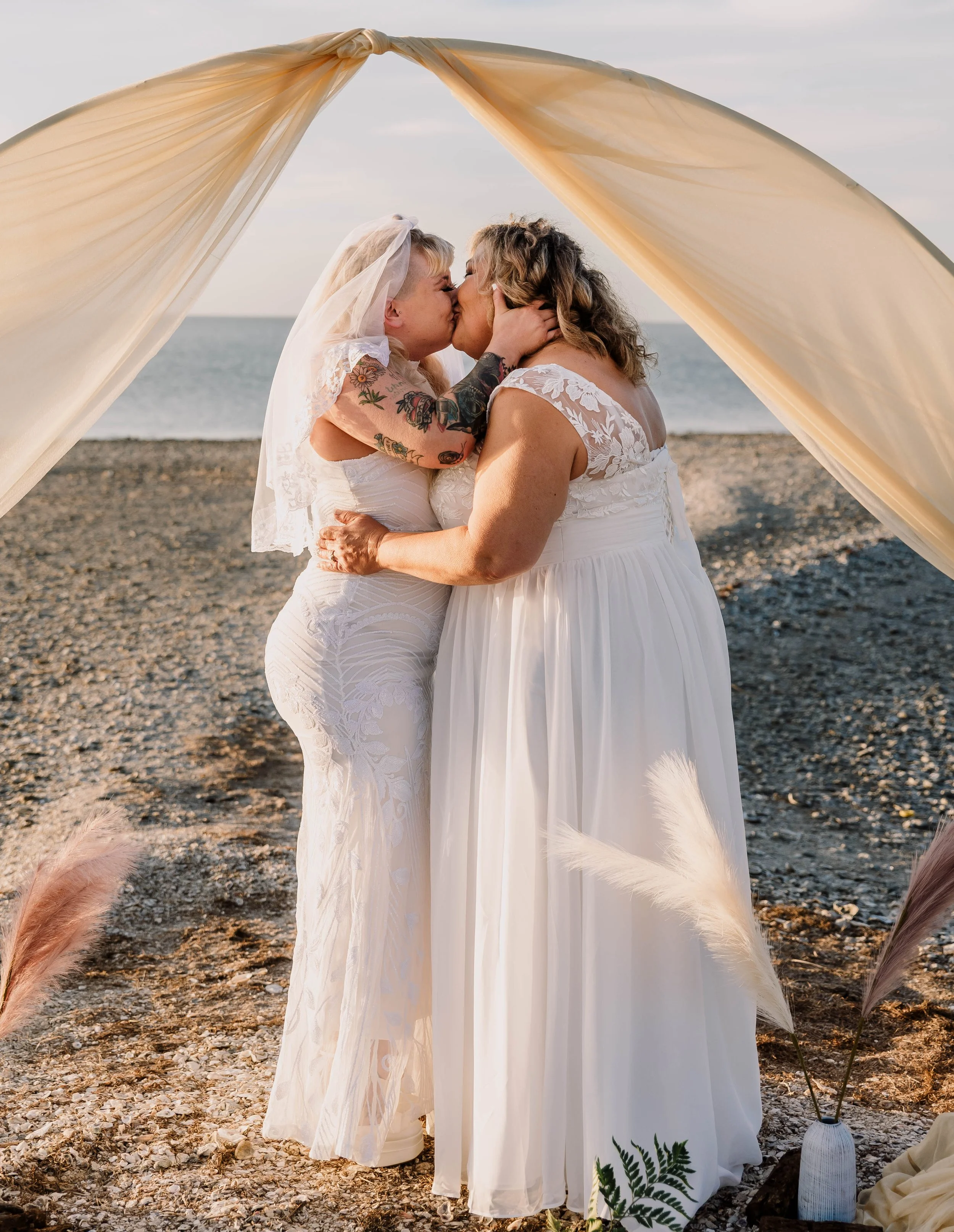 LGBTQ beach wedding ceremony on Padre Island, Texas officiated by The Love Officiant in Corpus Christi. Two brides sharing a kiss during a beach wedding ceremony on Padre Island, Texas, officiated by The Love Officiant in Corpus Christi.G