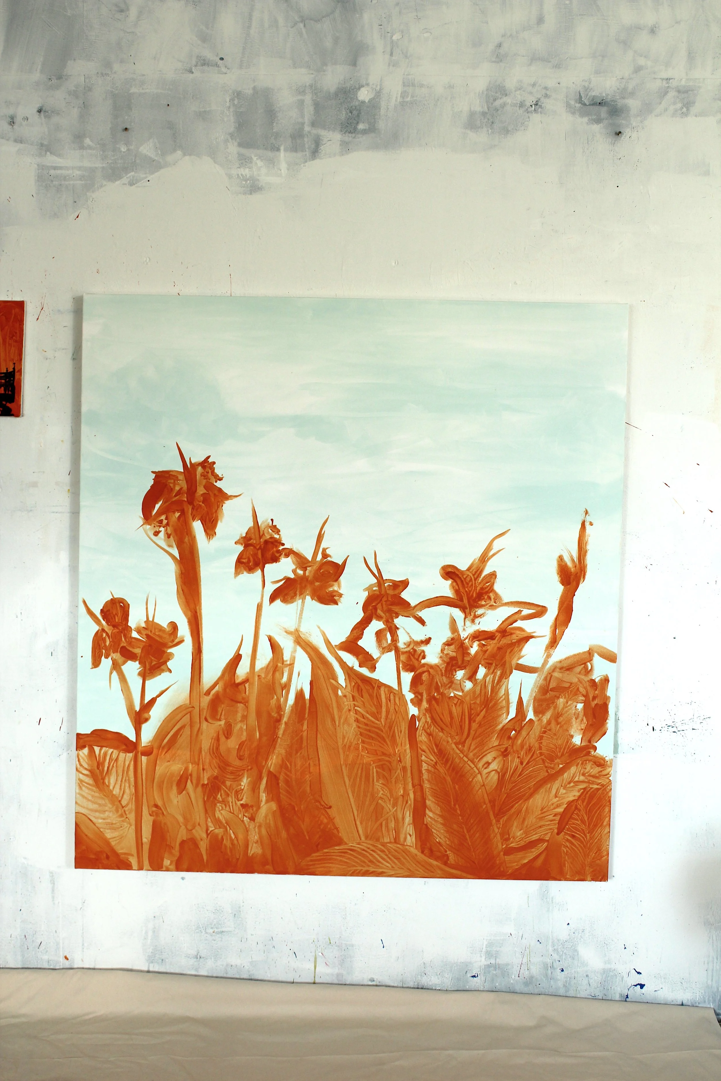Painting of orange flowers and leaves on a light blue sky background, hanging on a white wall.