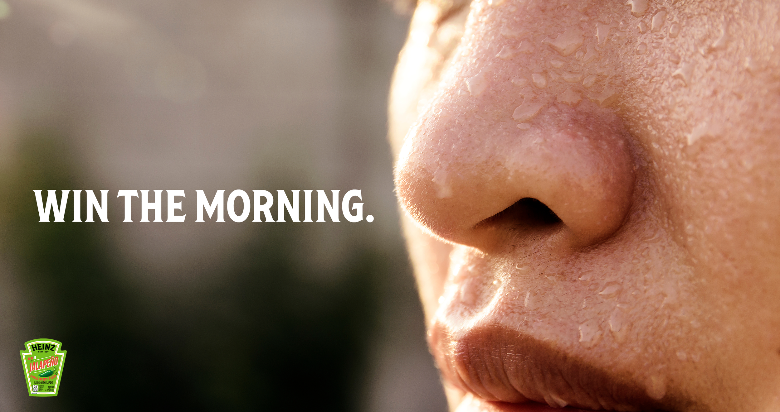 Speculative advertisement for Heinz jalapeno ketchup showing an extreme close-up focusing on a person's nose and upper lip, drenched in seat. Bold white text reads "WIN THE MORNING." A Heinz Jalapeño Ketchup logo is visible in the bottom left corner.