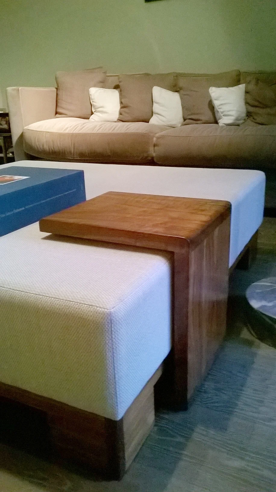 Walnut table floats above ottoman