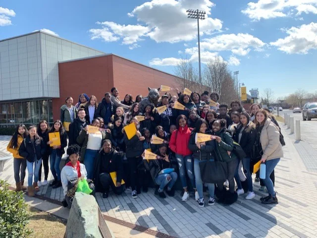 Students pose in front of Adelphi’s mascot. Photo Credit: Ms. Karen Giordano