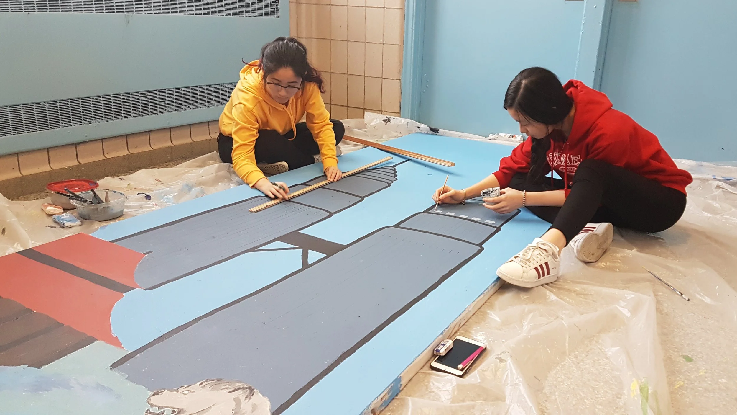 The Art Crew works on backgrounds for the stage. Photo Credit: Shamail Naseer