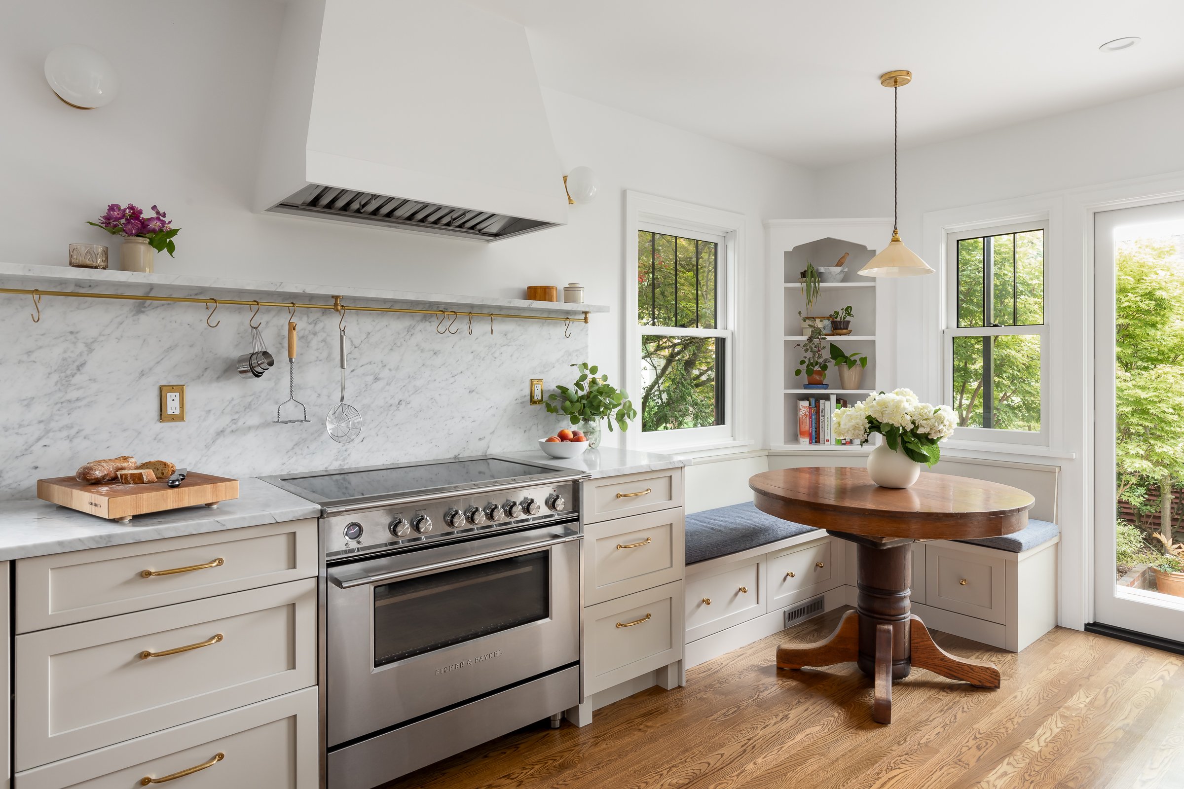 Custom cabinets and stove hood, marble backsplash and high-end induction cooktop