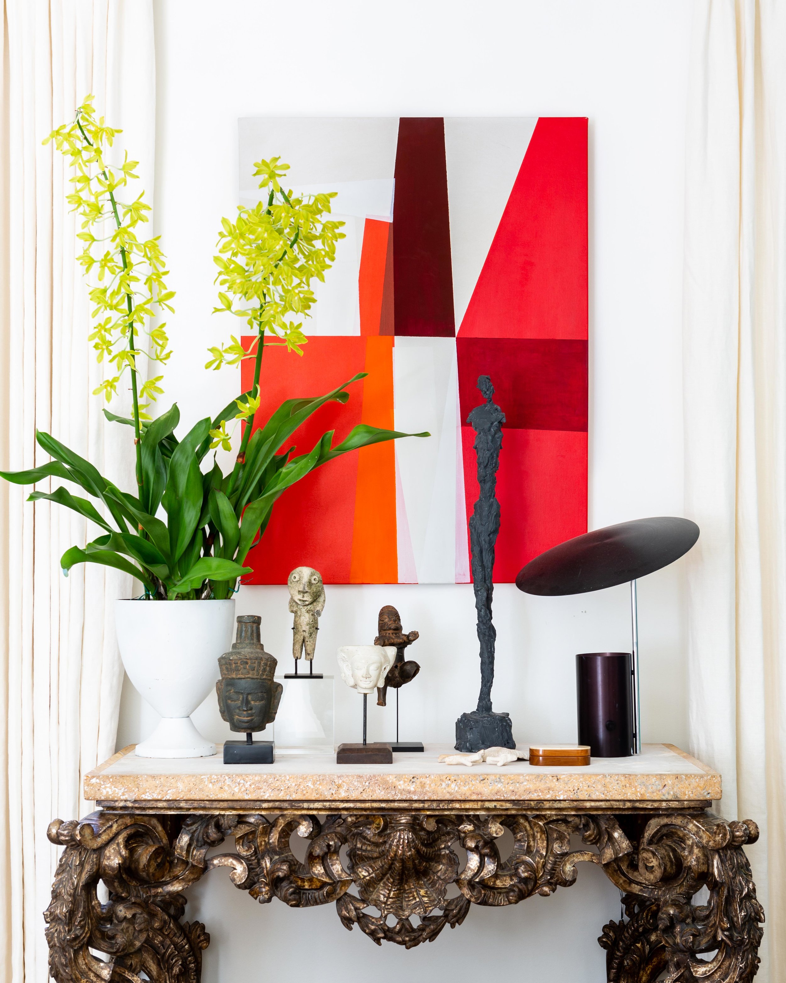 As a birthday present to himself, McLure bought this antique console from Interiors Market in Atlanta. A piece of abstract art by Catherine Booker Jones is displayed above it.