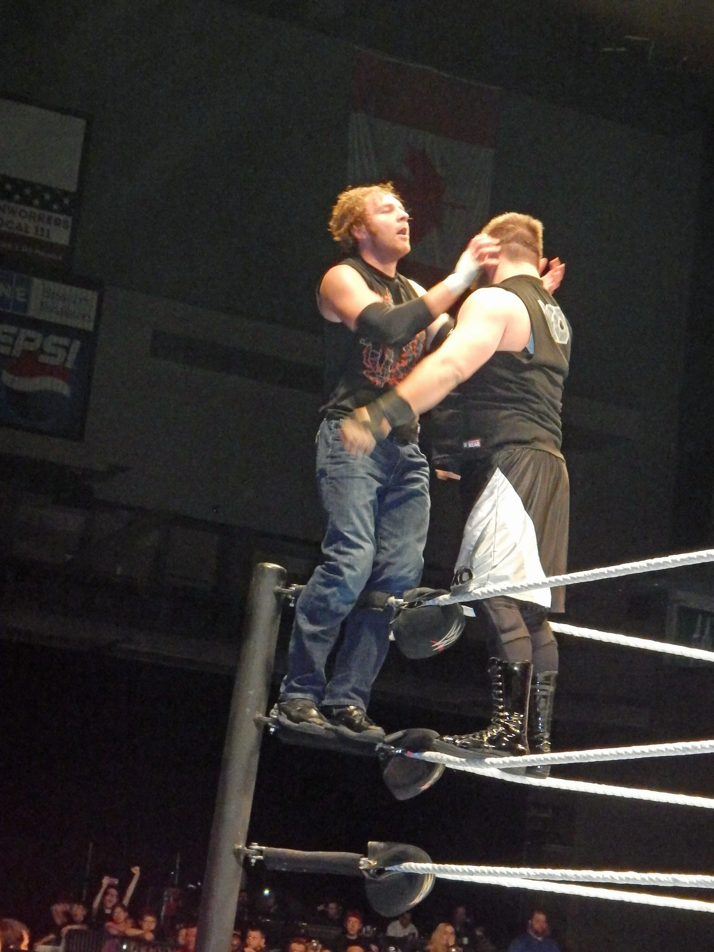 Dean Ambrose, left, stands on the second rope in the corner in a match against Kevin Owens at a WWE live event in Moline, Ill. on March 6, 2016. (Photo by Mike Pankow)