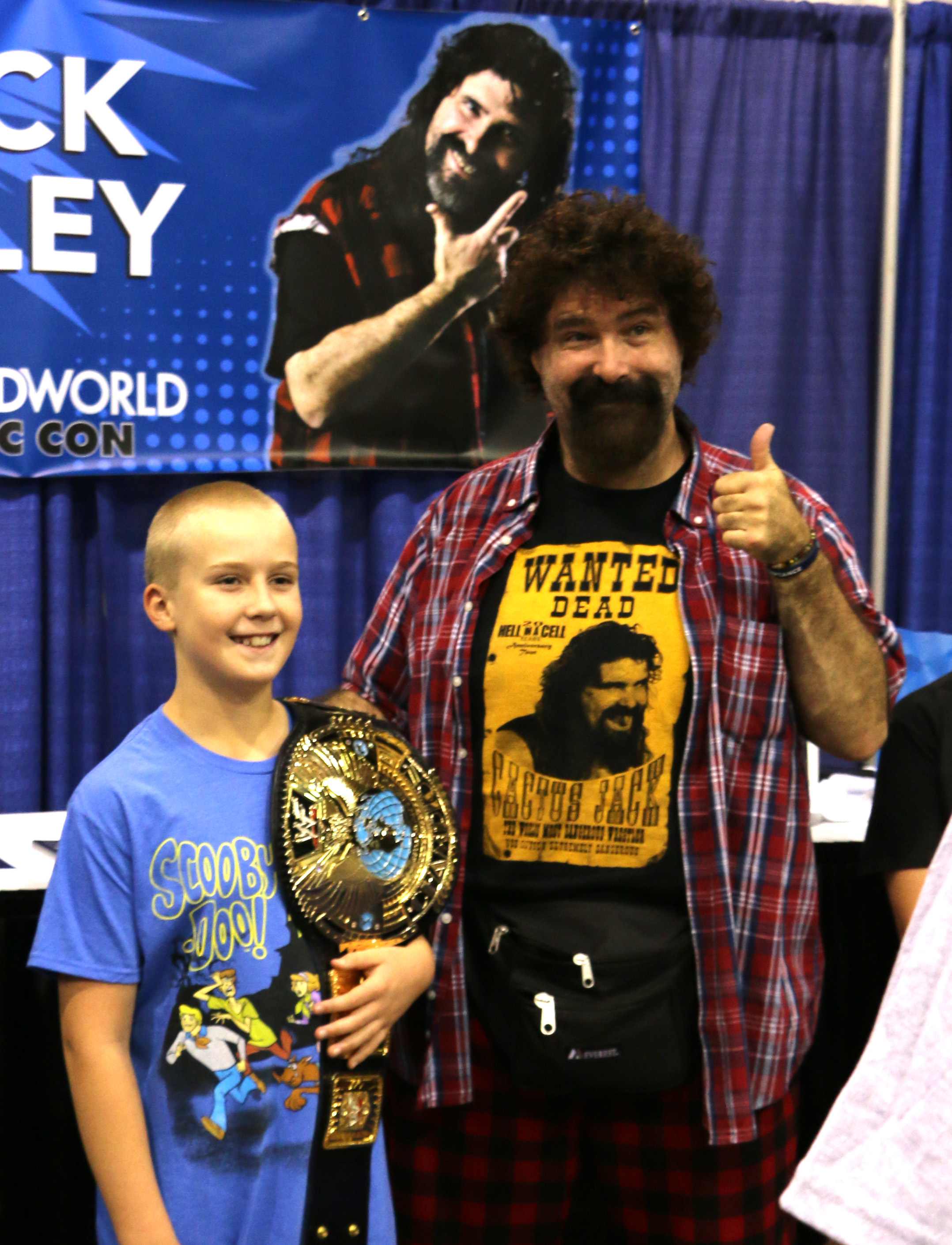 WWE Hall of Famer Mick Foley, right, poses for a picture with a young fan at Wizard World Chicago on Friday, August 24, 2018. (Photo by Mike Pankow)