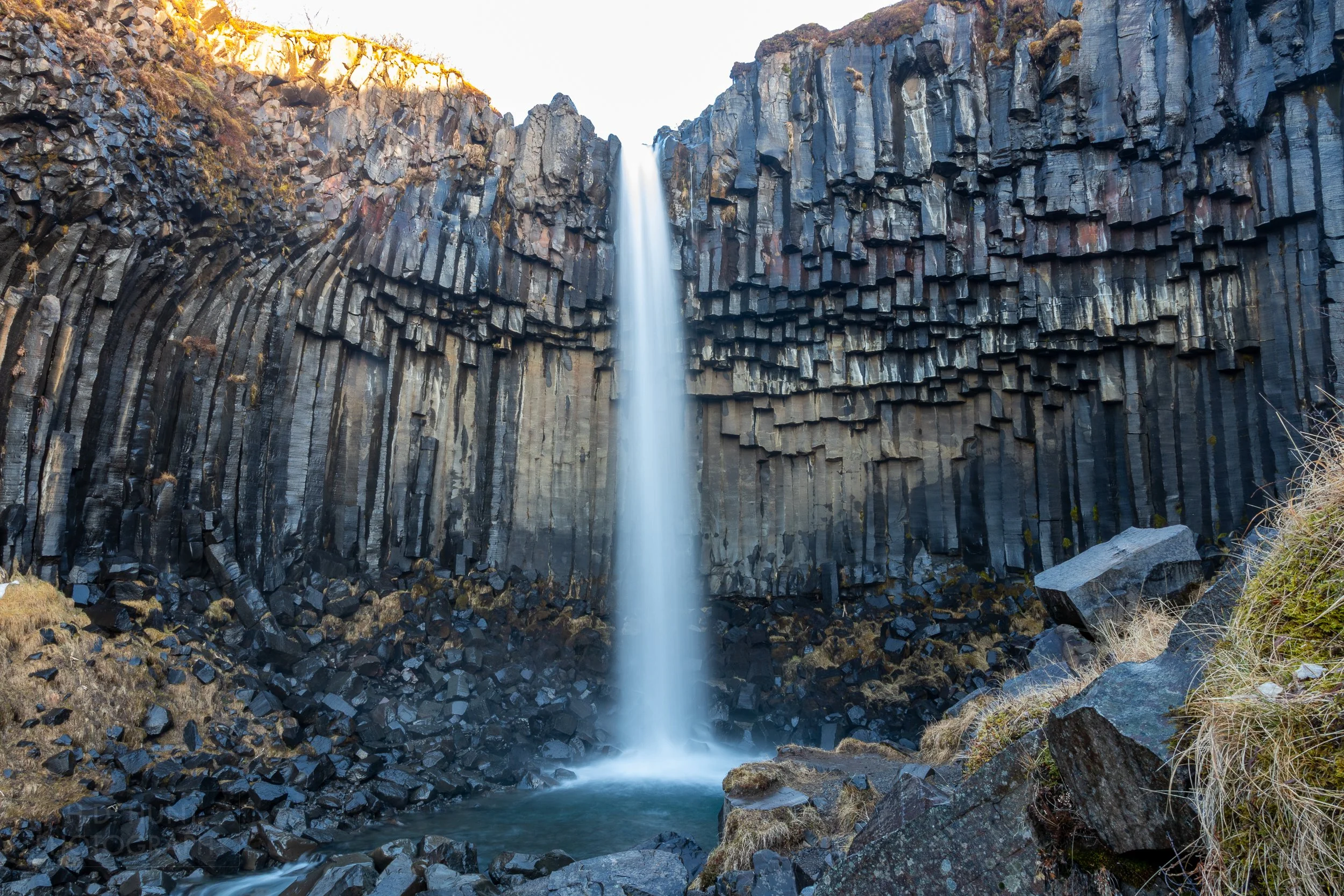 The waters of Svartifoss cascade over black basalt columns, Iceland.