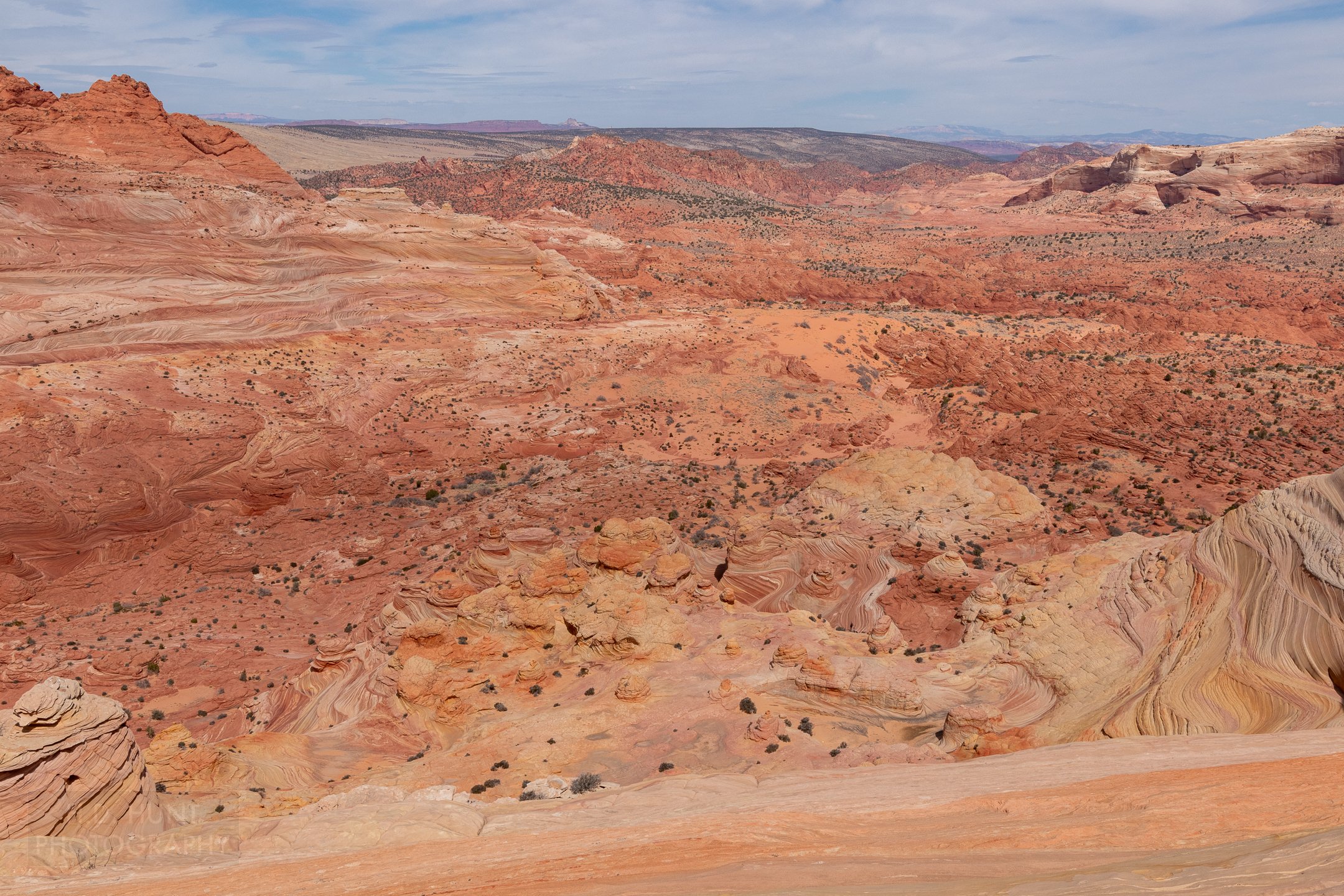 Deformed red sandstone - including The Wave - is seen from a cliff in Coyote Buttes North, Paria Canyon-Vermilion Cliffs Wilderness, Arizona, United States.
