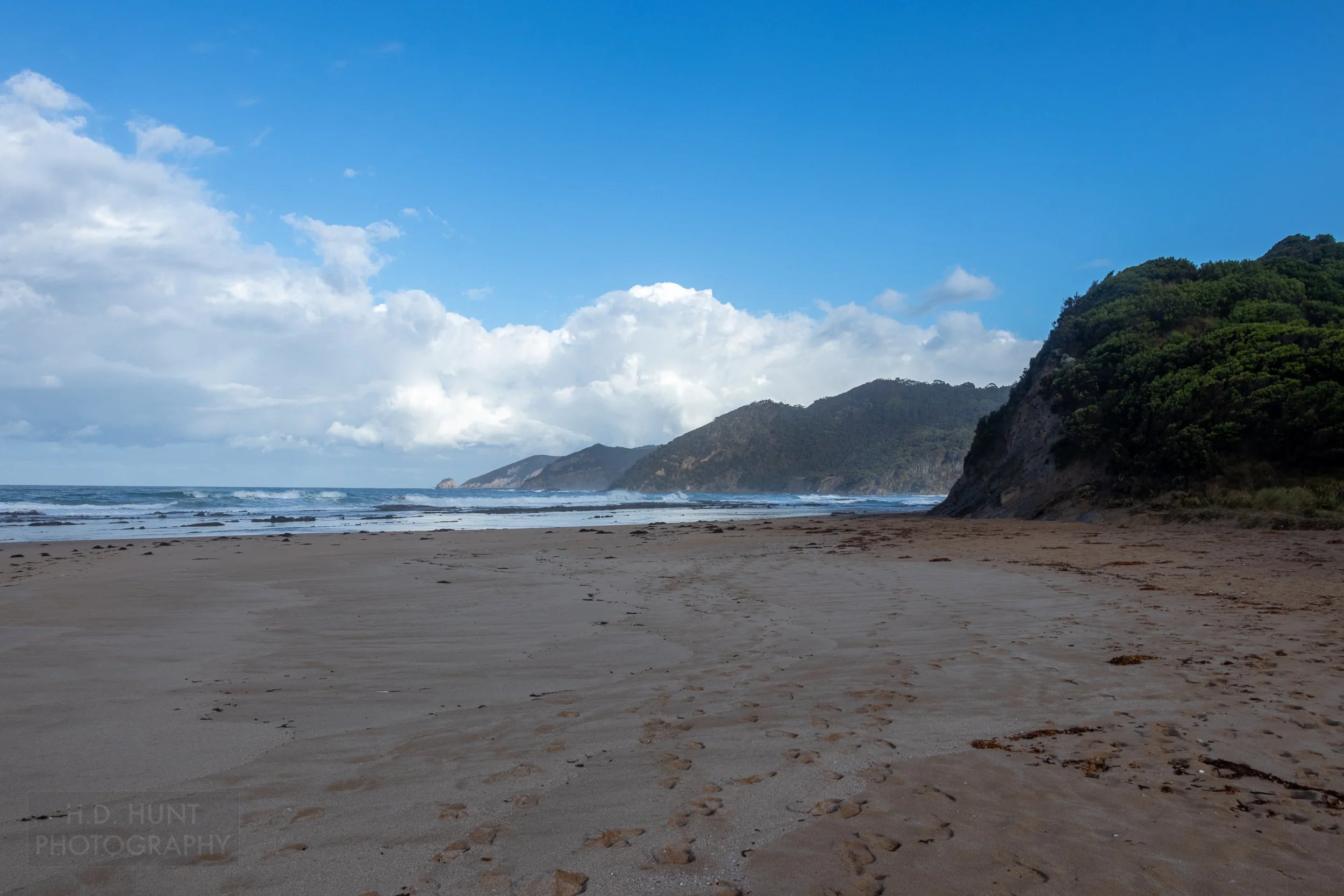 A wide beach stretches towards the sea along The Great Ocean Walk, Victoria, Australia.