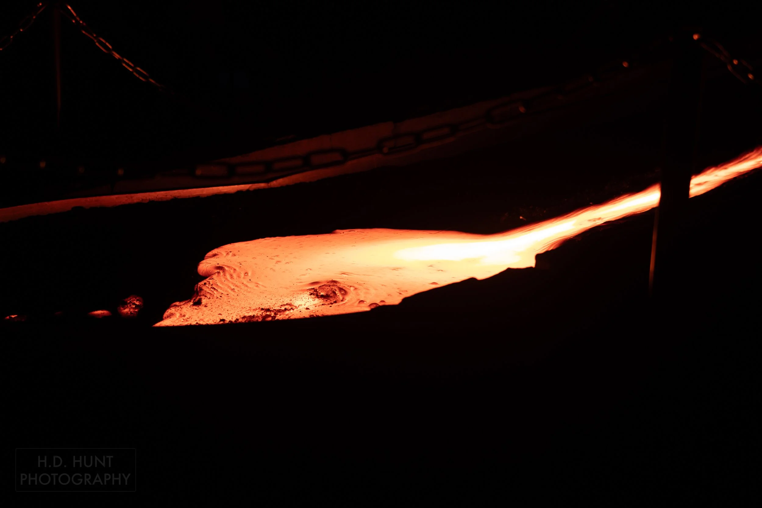 Molten lava pools in a dark-colored trough at the Lava Show, Vik i Myrdal, Iceland.