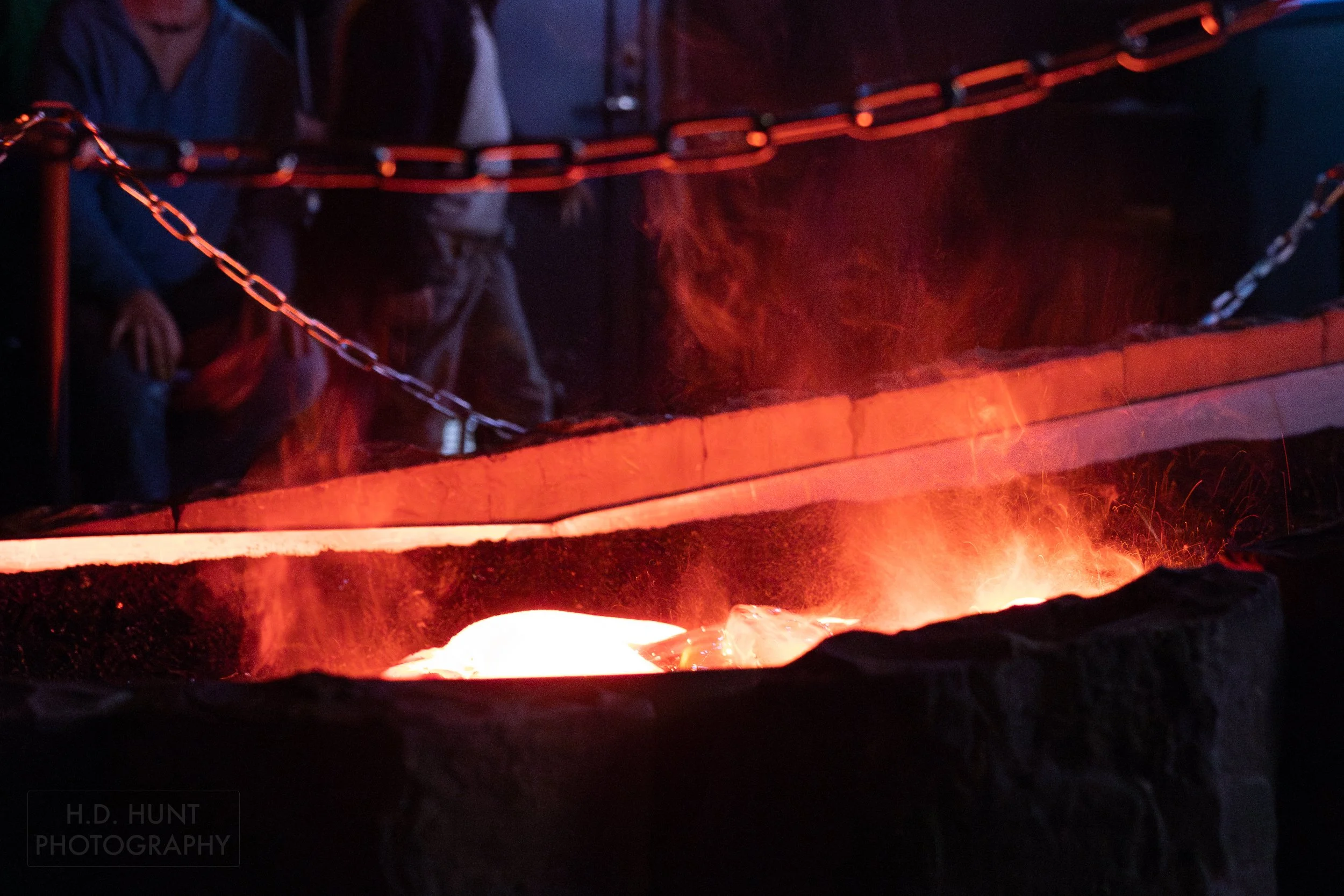 Molten lava sizzles and steams in a black trough at the Lava Show, Vik i Myrdal, Iceland.