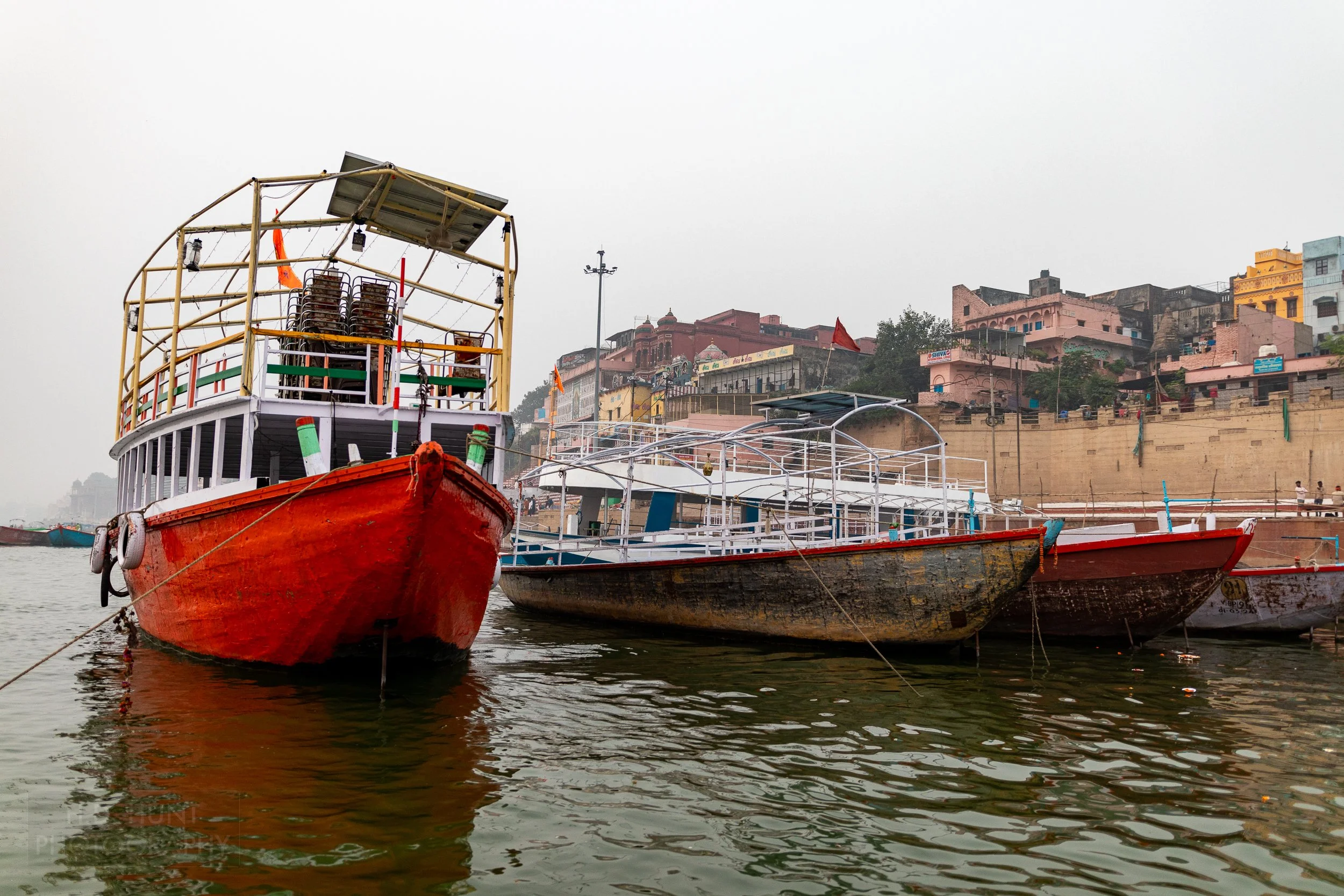 Three boats are tied up along the Ganges River, Varanasi, India.