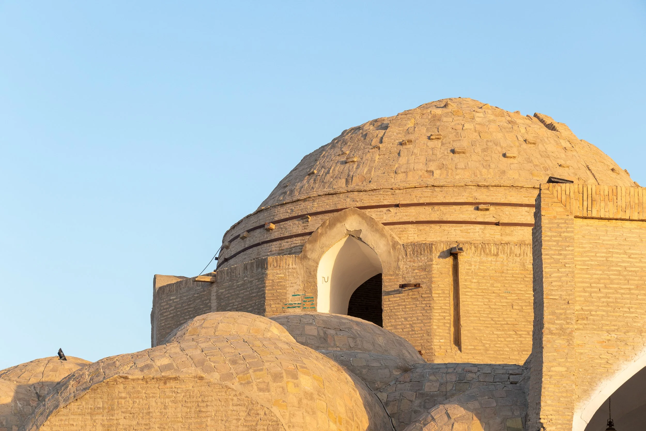 The dome of Toqi Telpakfurushon is illuminated by the rising sun, Bukhara, Uzbekistan.
