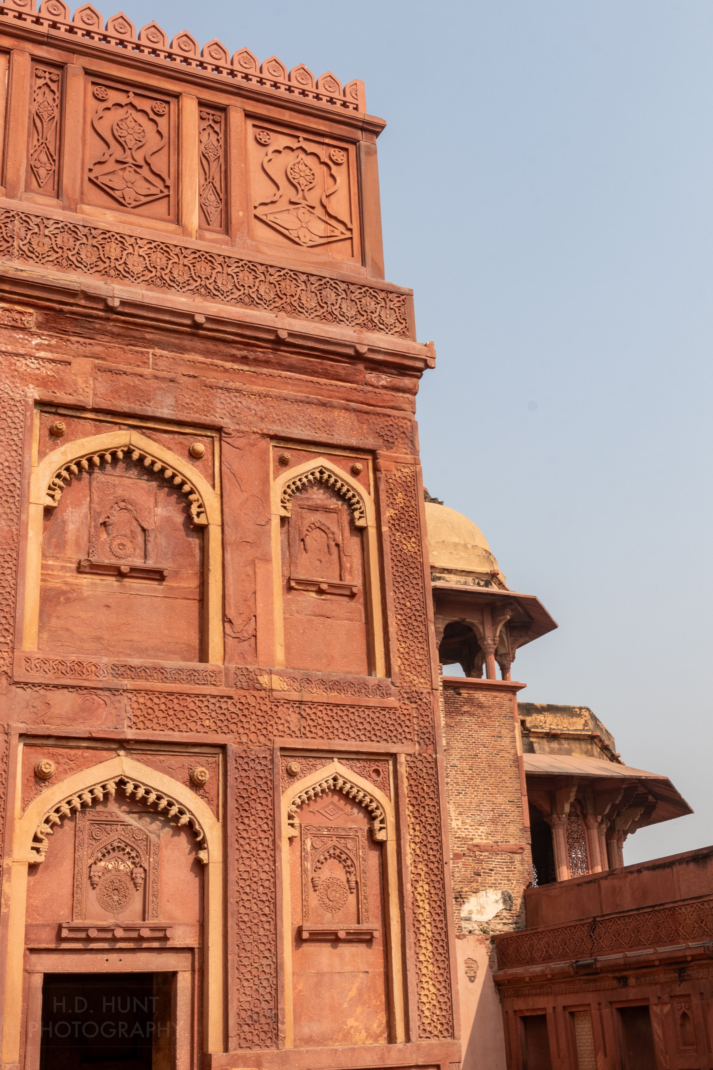 Two cupolas and a large red wall are seen inside Agra Fort, Agra, India.