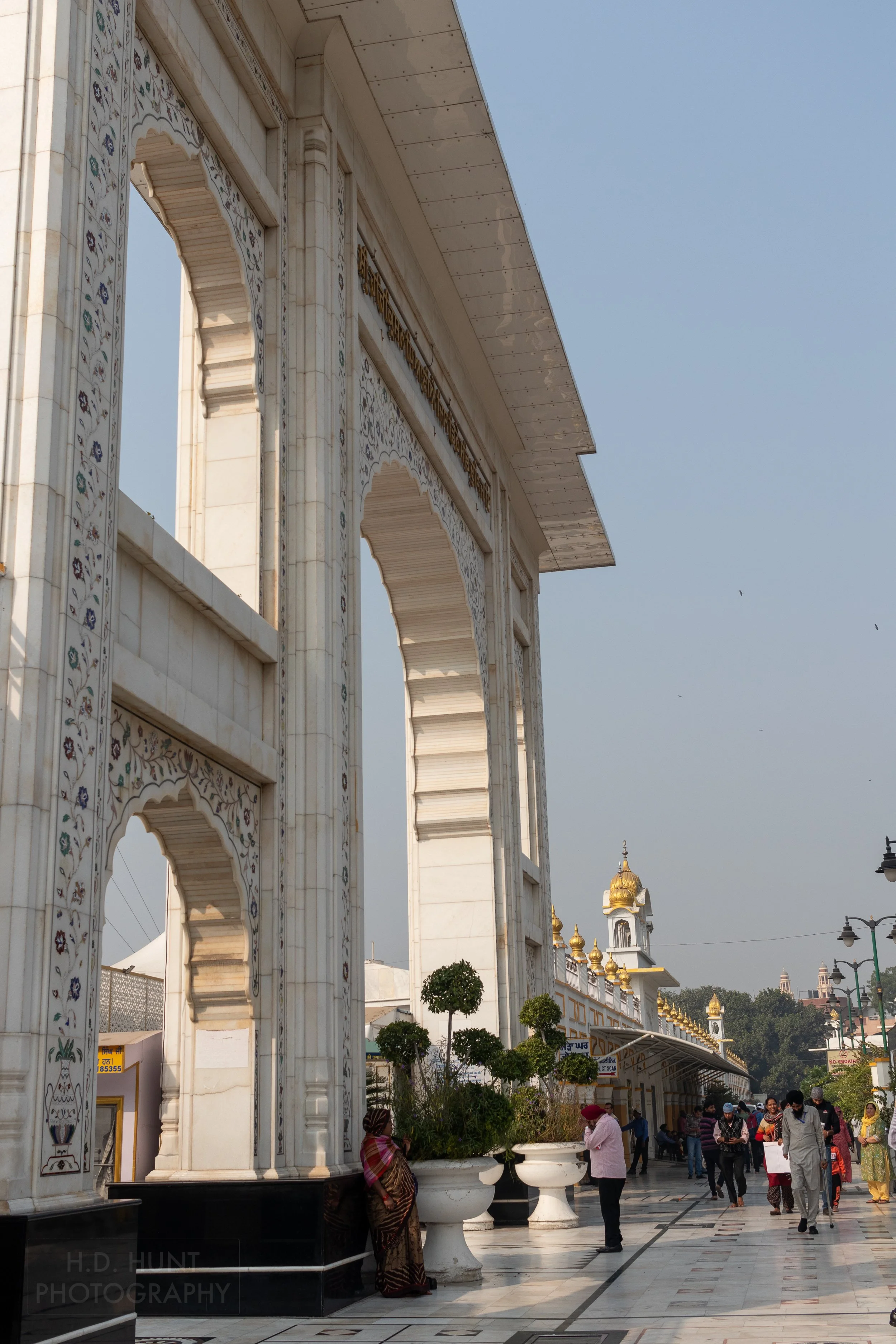 The large white stone entrance archway of Gurdwara Bangla Sahib, Delhi, India.