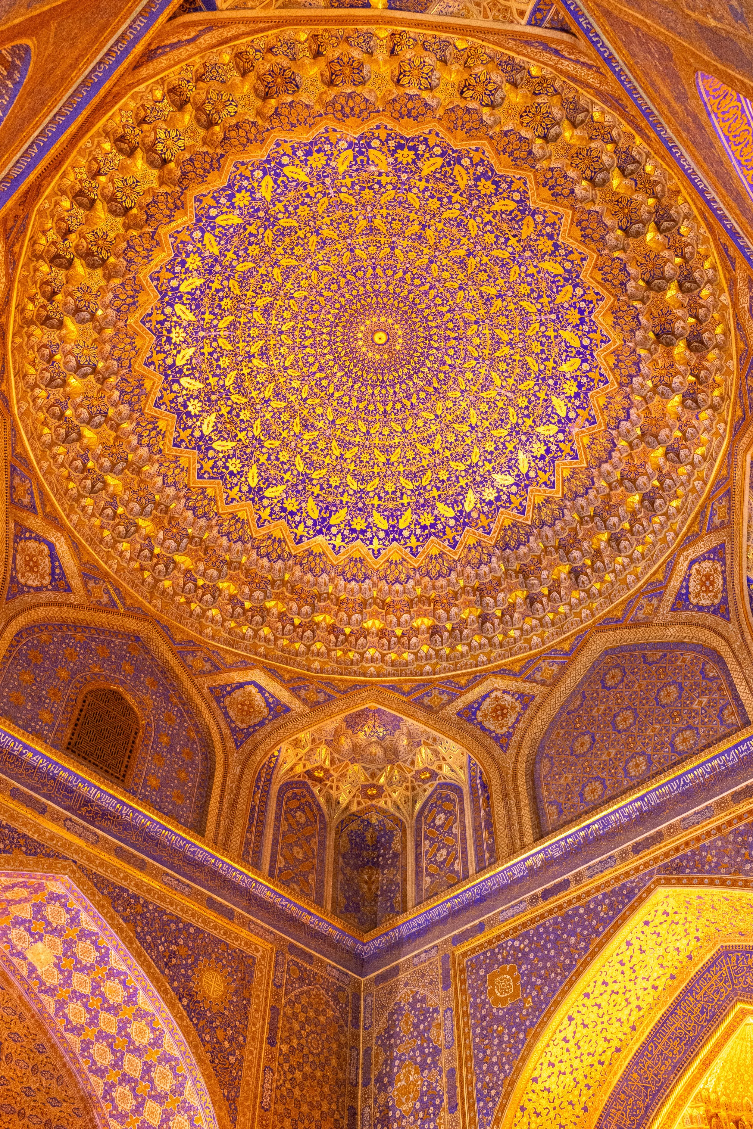 Interior of the dome at the Museum of the History of the Registan Complex featuring vibrant gold and blue paint, Registan, Samarkand, Uzbekistan.
