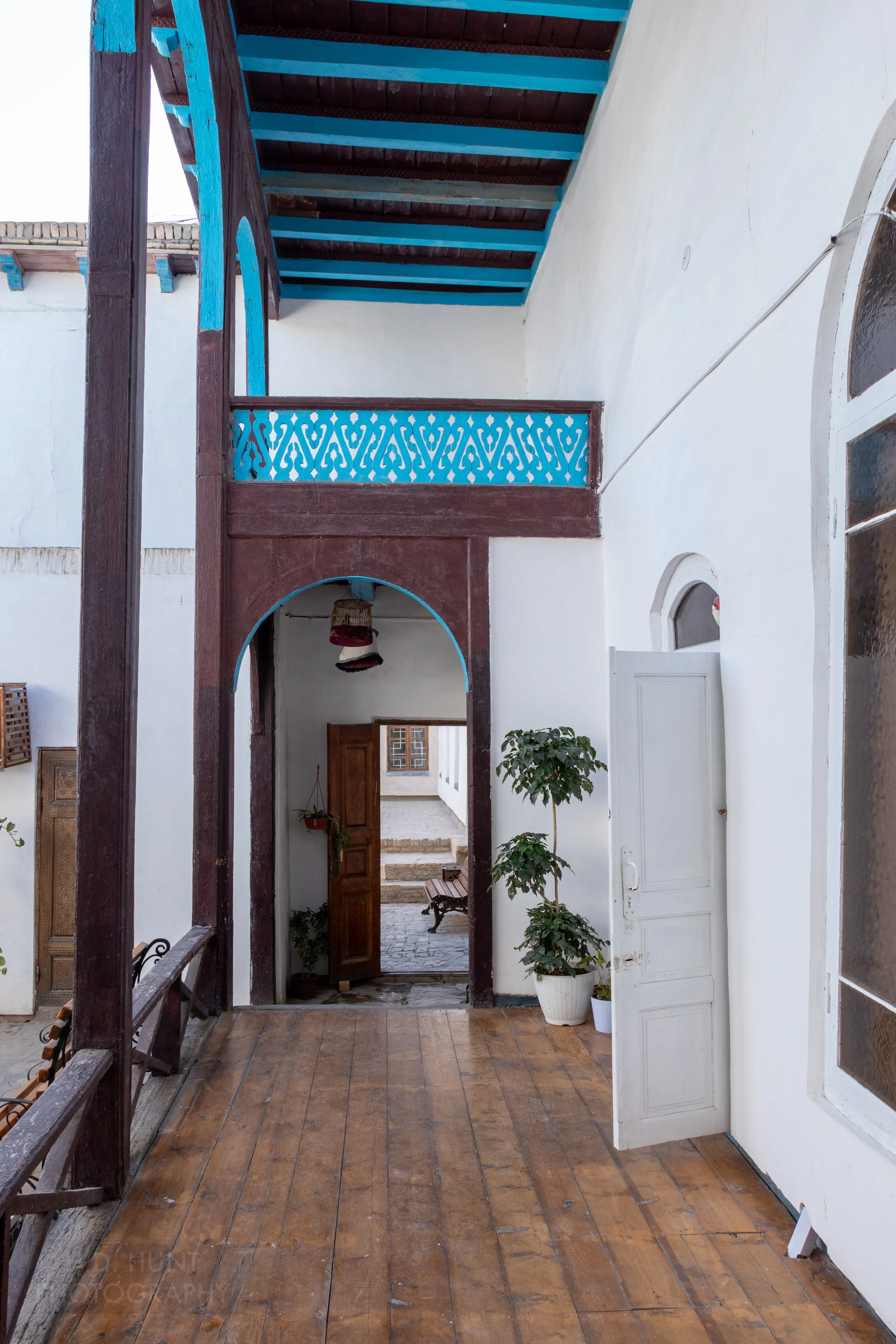 A corridor with a wooden floor and wood archway inside the Ark of Bukhara, Uzbekistan.