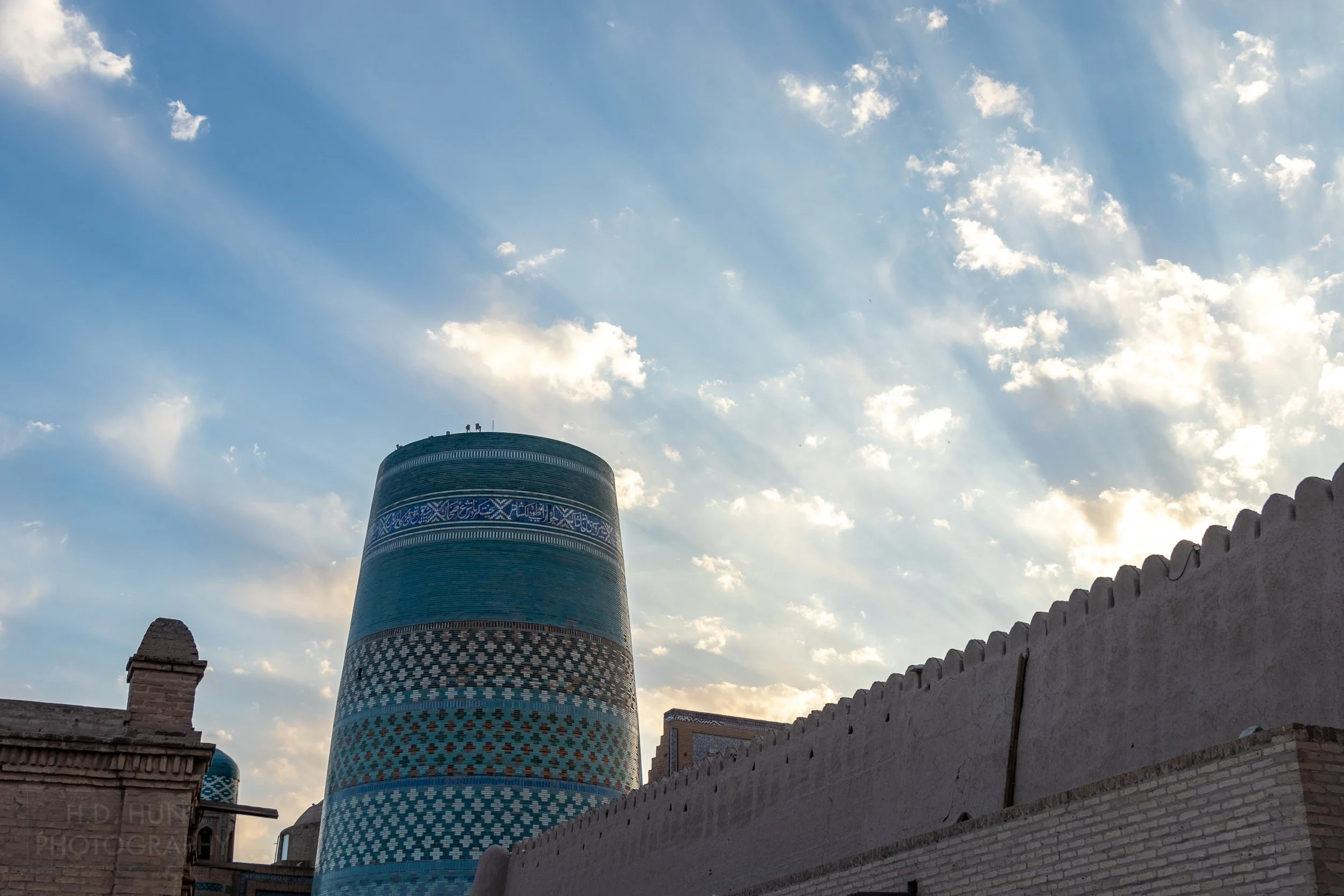 Rays of light peak over a stone wall in Khiva's Itchan Kala inner city, Uzbekistan.