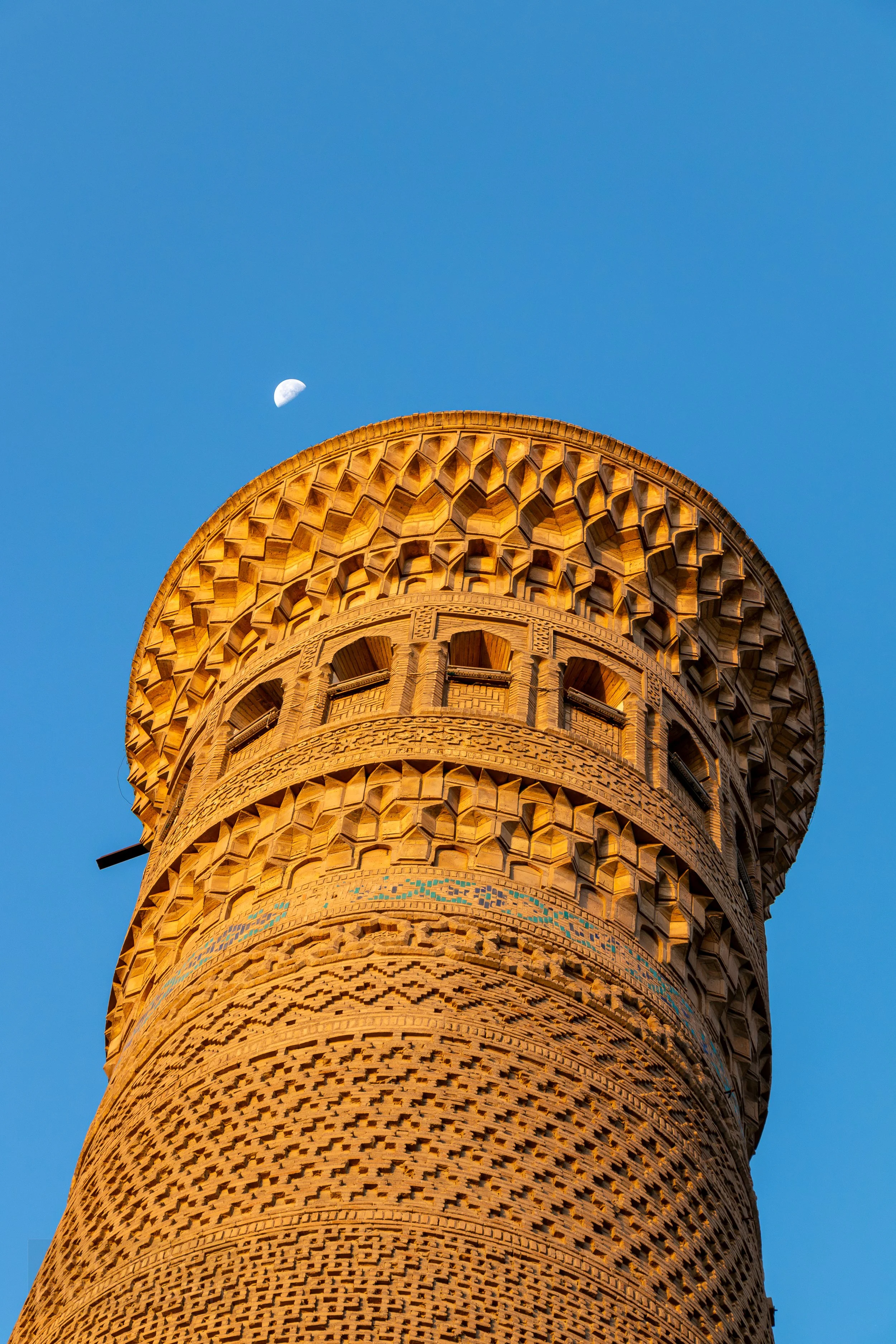 A close-up of the top of the Kalan Minaret with the Moon present in the background, Bukhara, Uzbekistan.