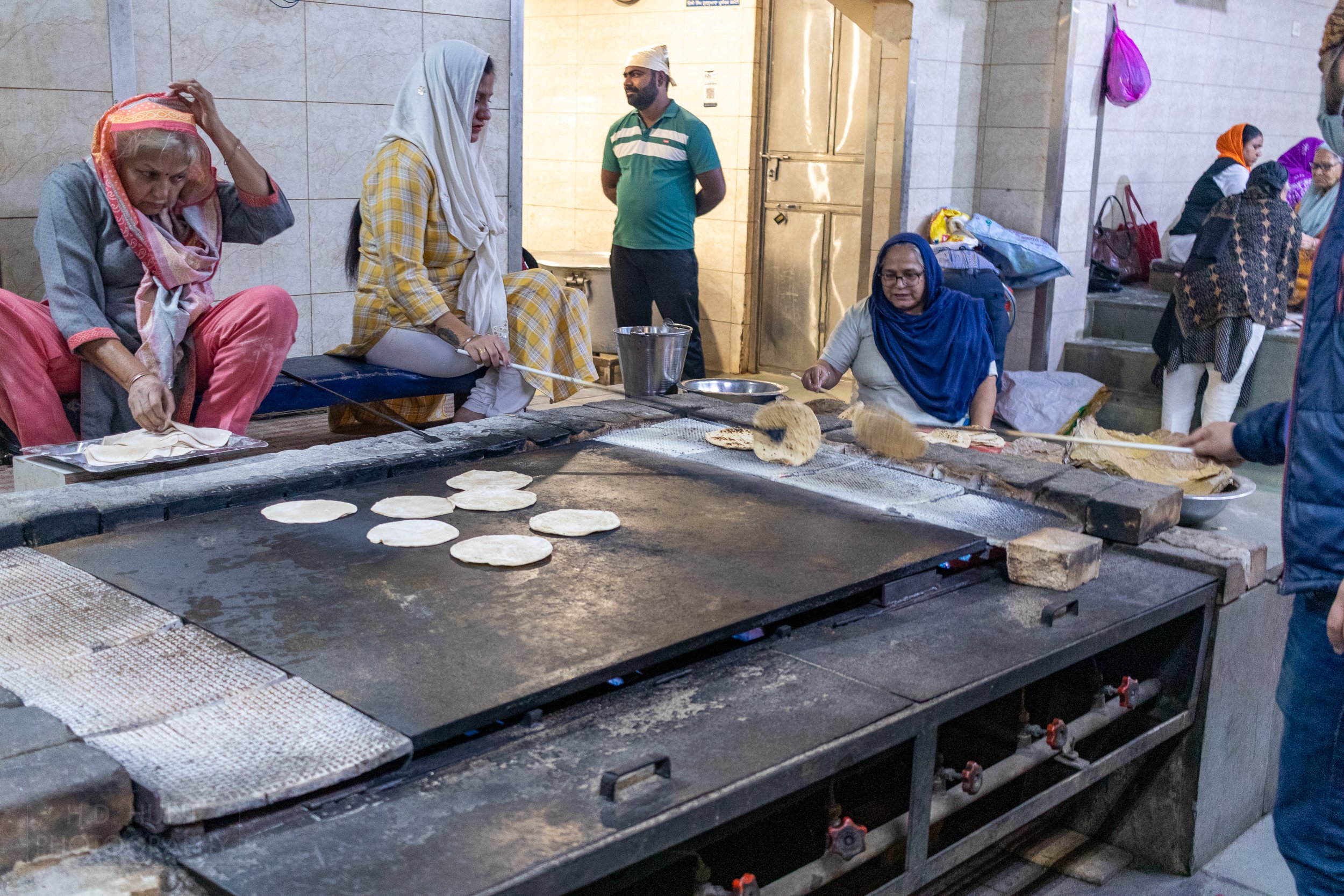 Women prepare bread inside the kitchen of Gurdwara Bangla Sahib, Delhi, India.
