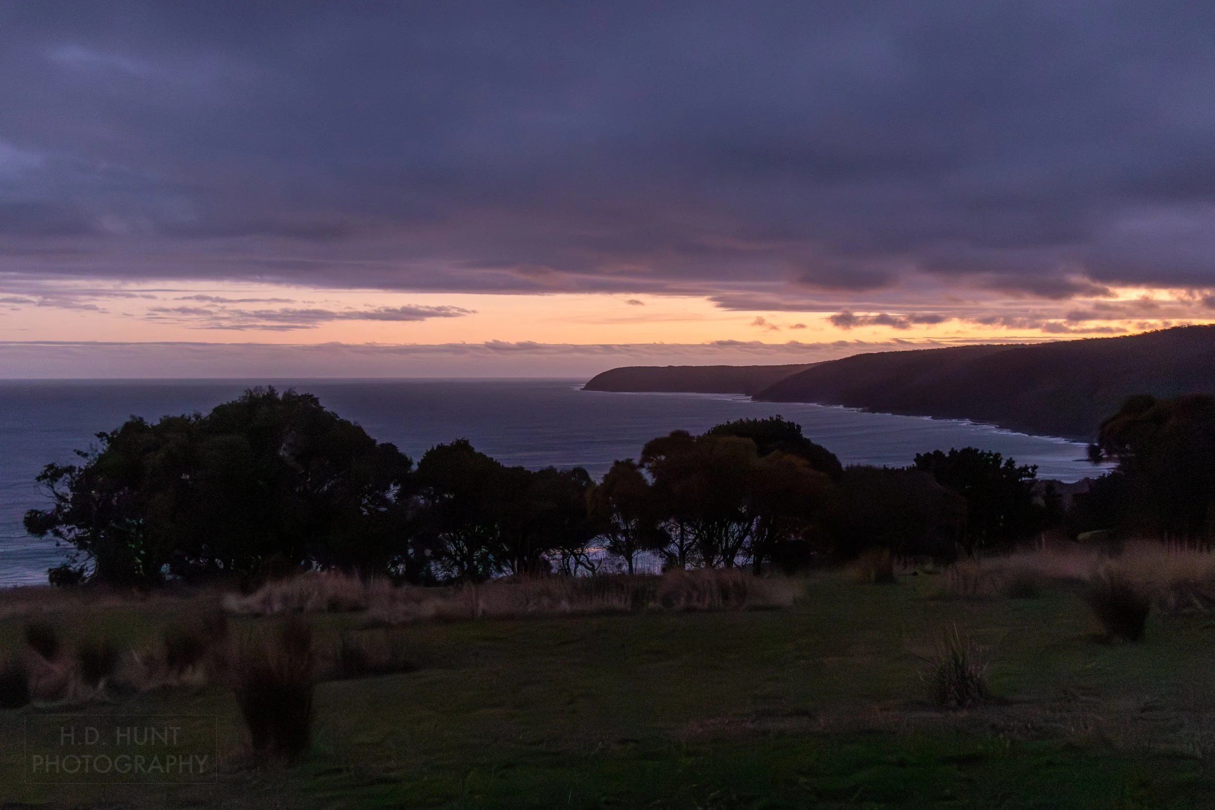 Sunset behind cliffs along the Southern Ocean at Wildlife Wonders, Apollo Bay, Victoria, Australia.
