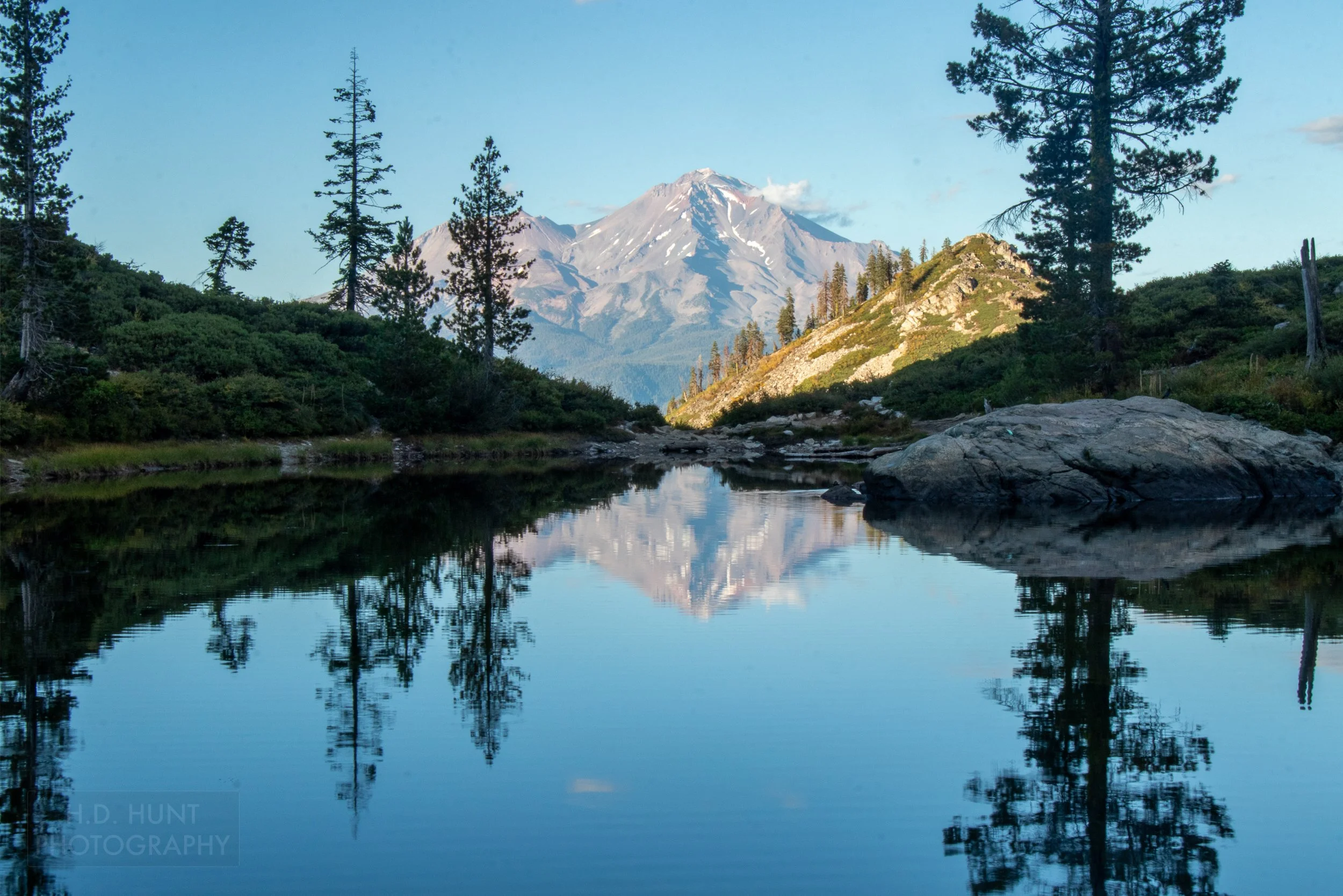 Mount Shasta is reflected in a small lake, Shasta-Trinity National Forest, California, United States.