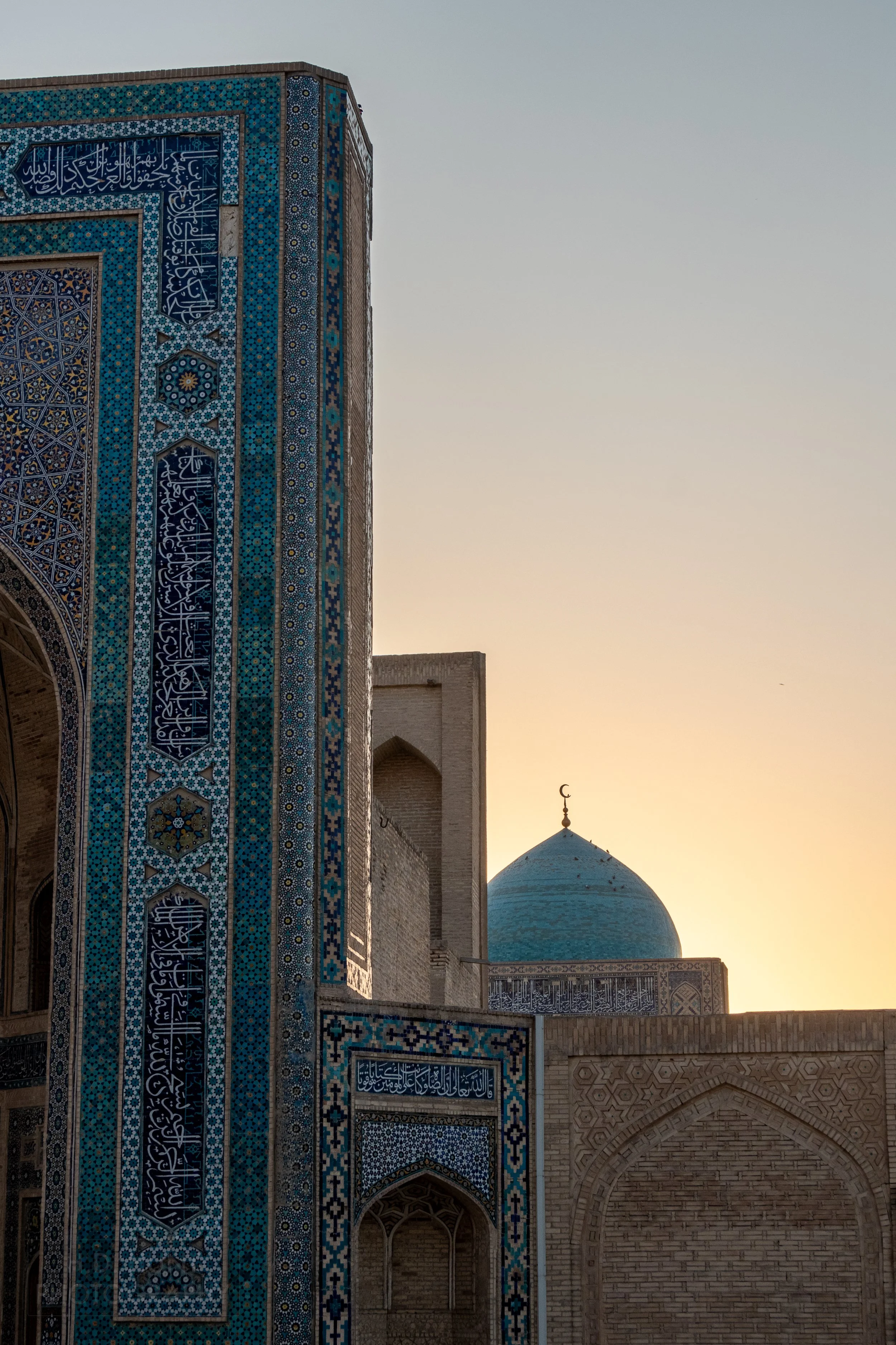 Sunset behind the blue dome of the Kalan Mosque in Bukhara, Uzbekistan.