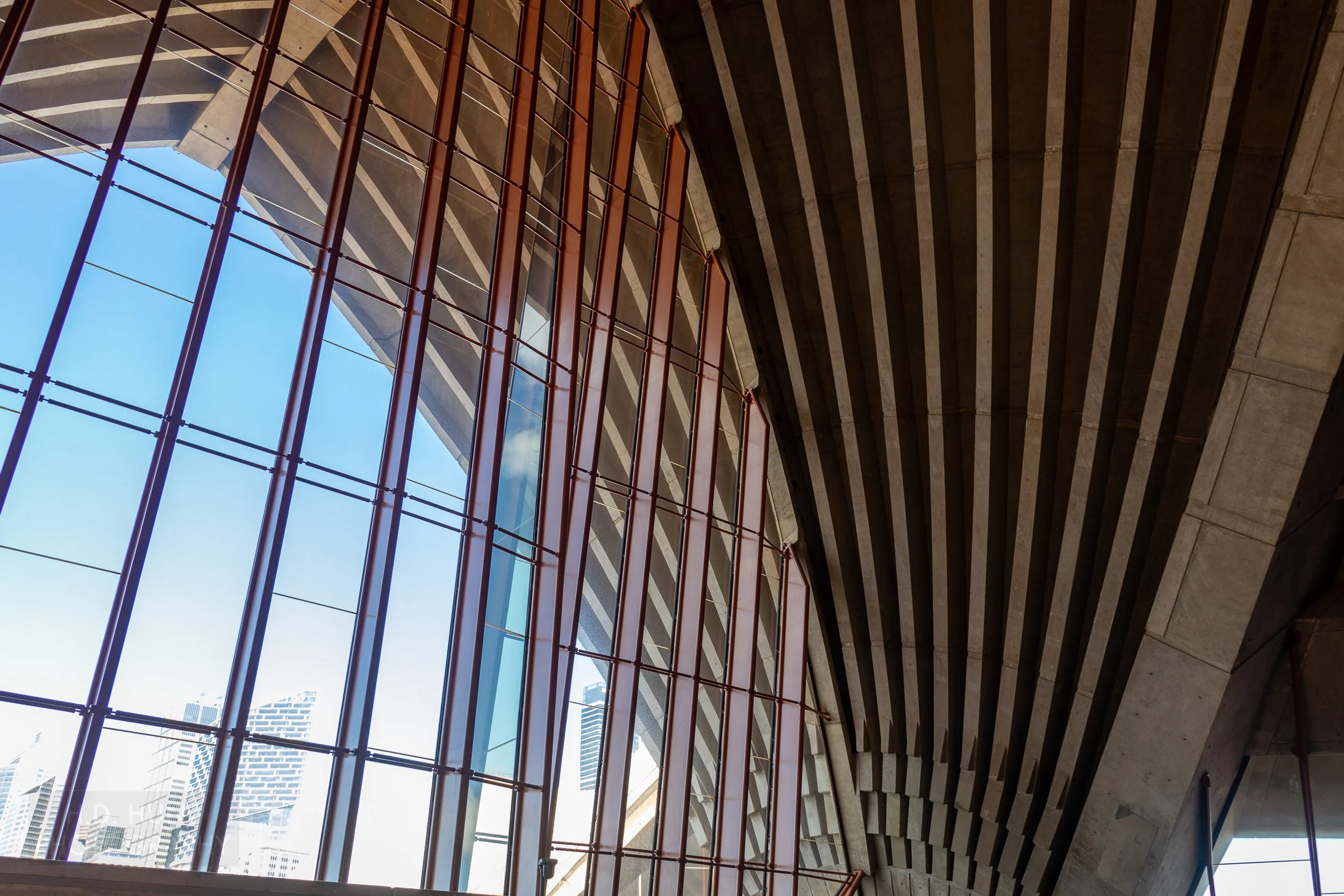 Sydney Opera House roof supports are seen in the buildings interior beside a large window, Sydney, New South Wales, Australia.