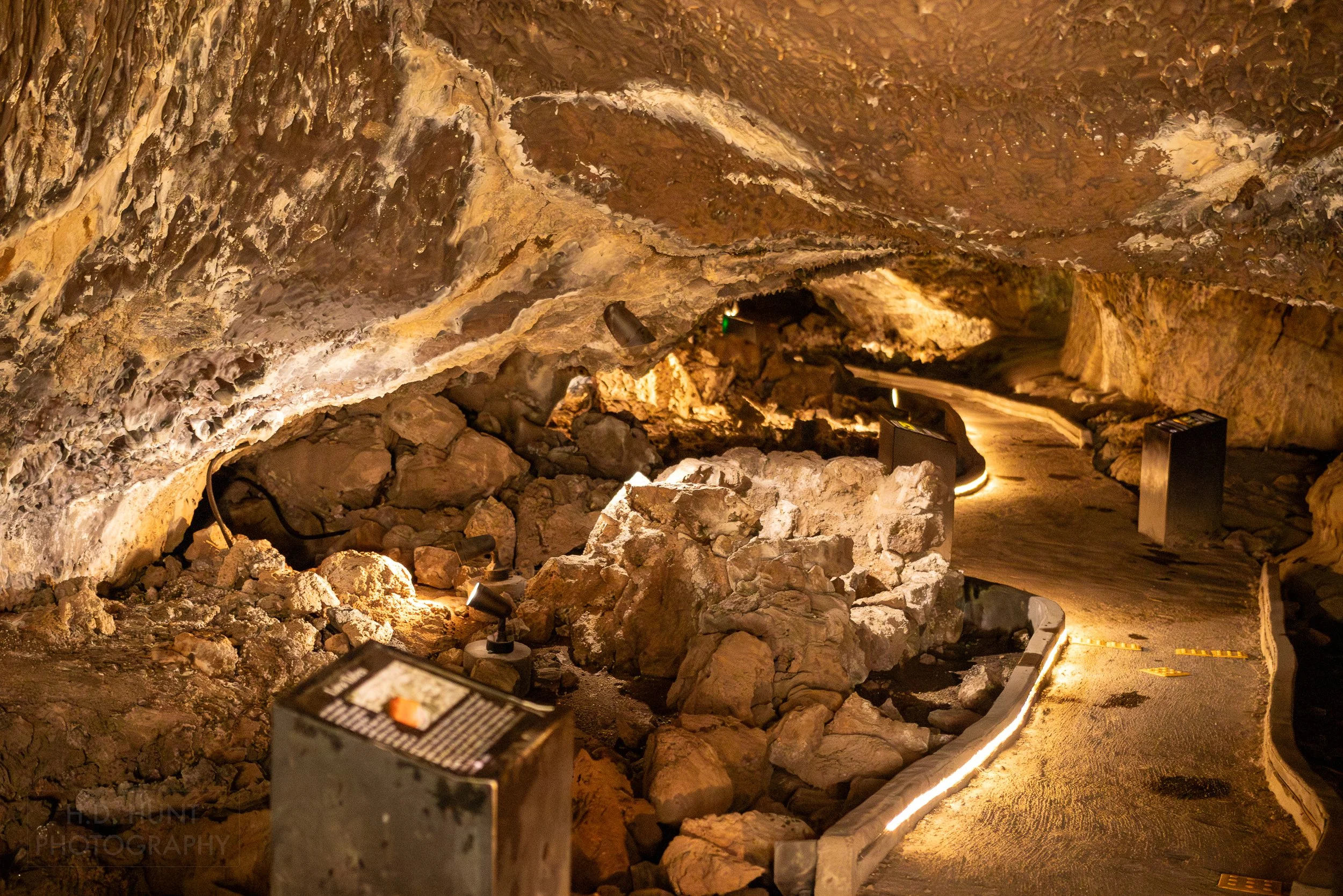An illuminated concrete walking path winds through a lava tube, Lava Beds National Monument, California, United States.