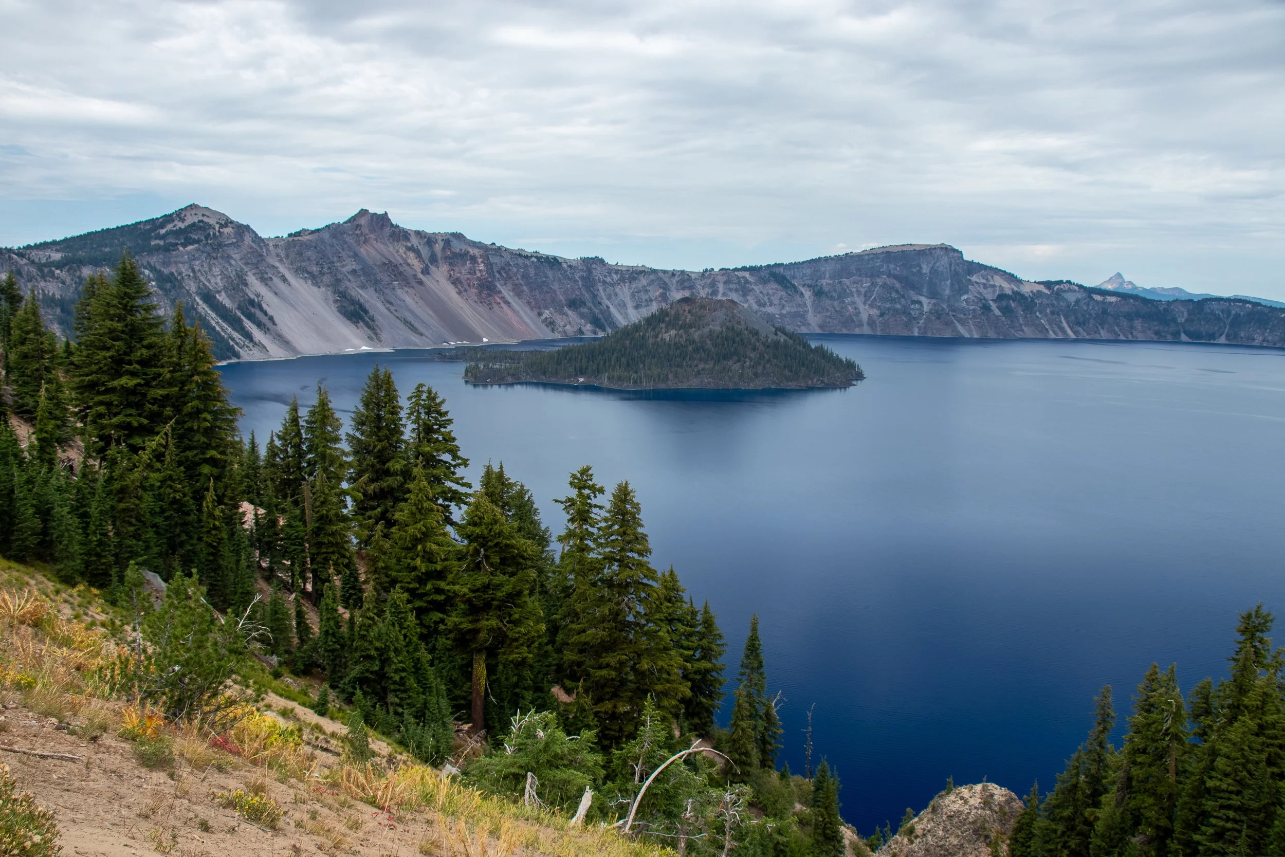 A view of the blue waters of Crater Lake with Wizard Island in the background from the trail up Garfield Peak, Crater Lake National Park, Oregon, United States.