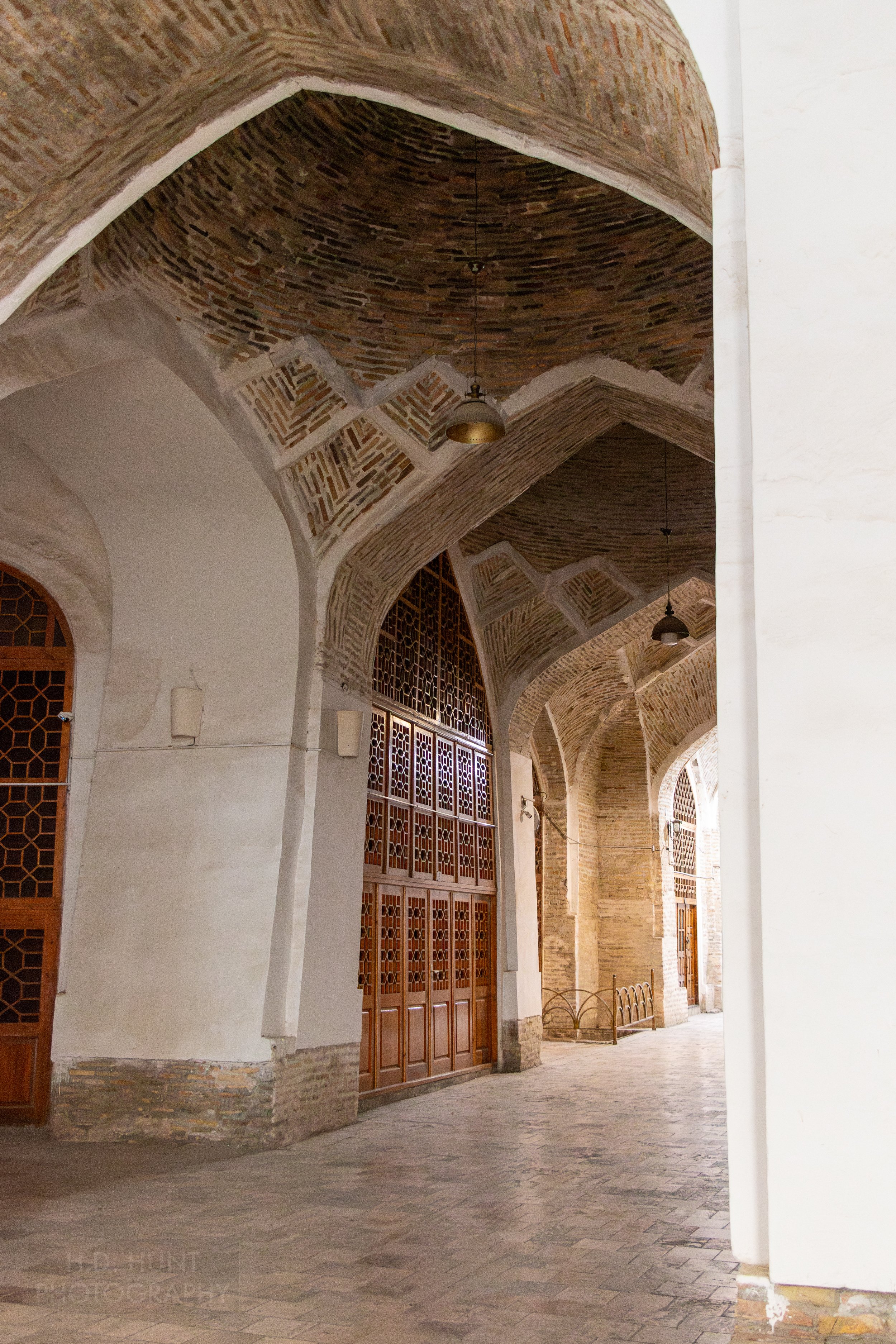 Wooden doors topped with large wooden screens inside the Toqi Telpakfurushon market dome, Bukhara, Uzbekistan.