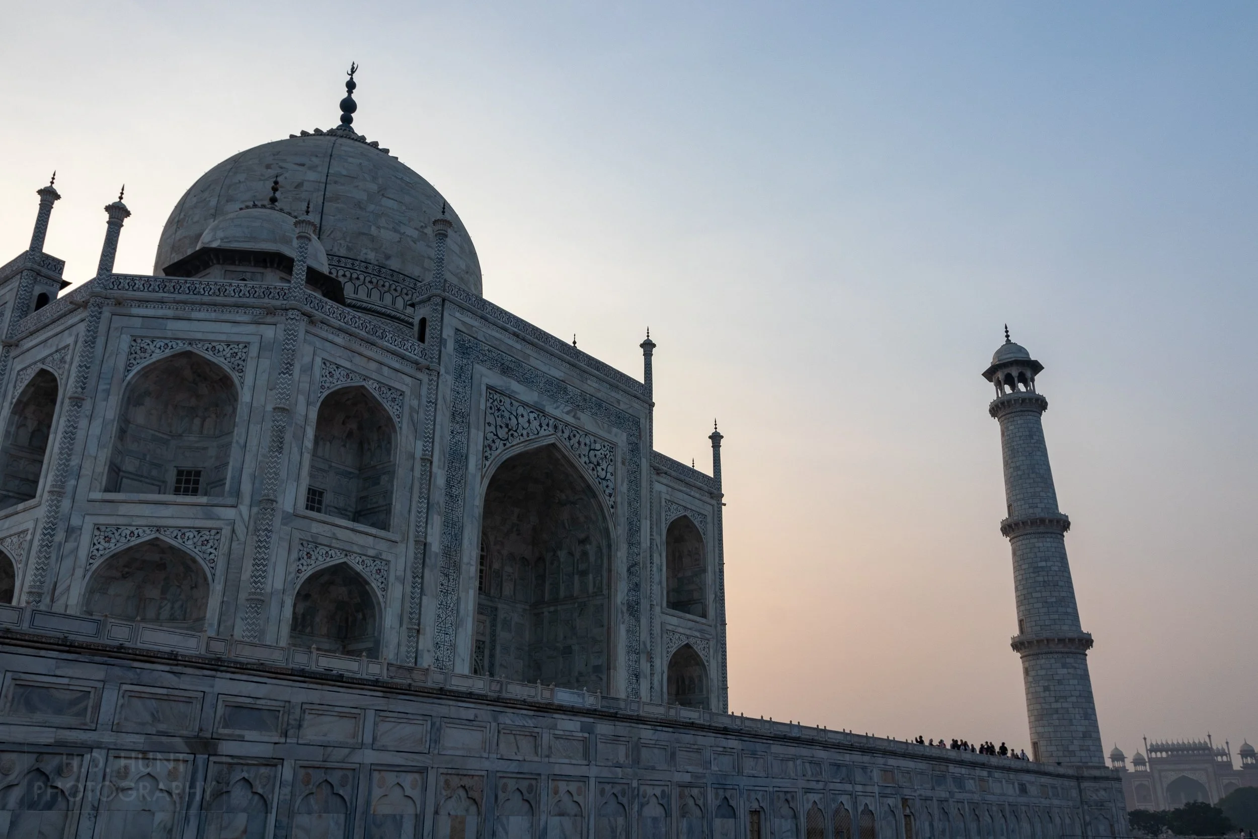 An orange and blue sky is seen behind a silhouetted Taj Mahal, Agra, India.
