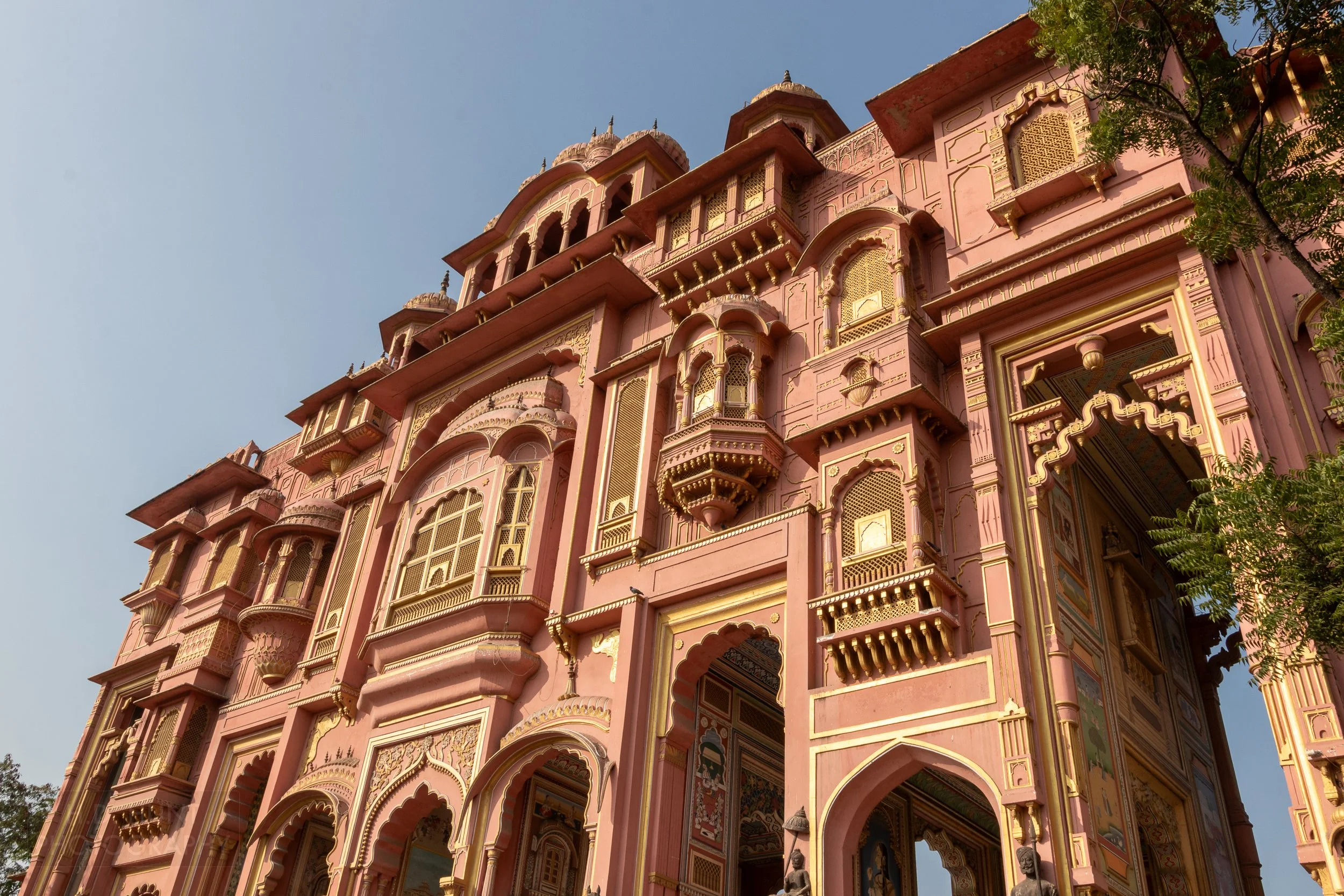 The pink and yellow multi-windowed facade of the Patrika Gate, Jaipur, India.