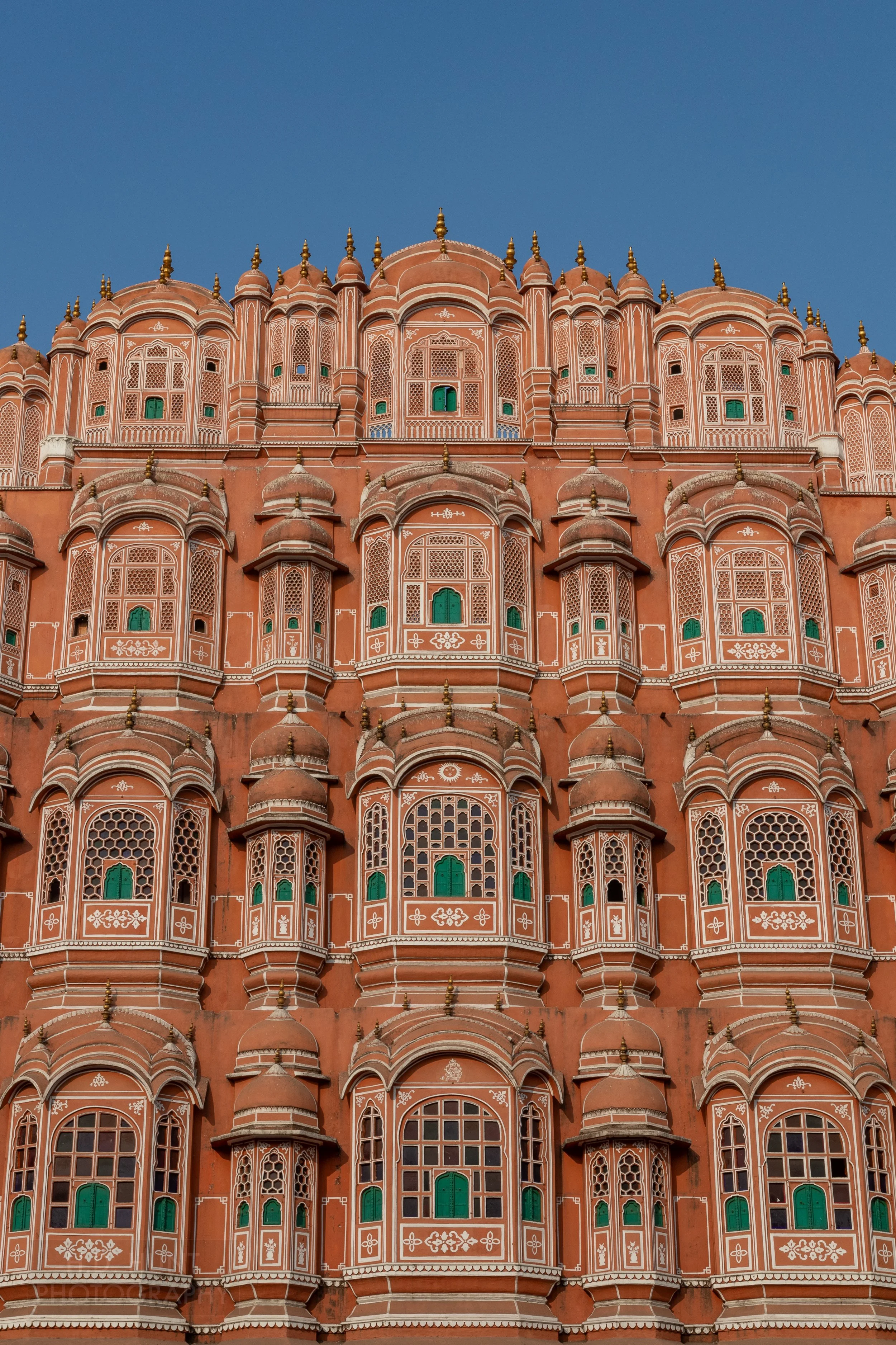 The pink and white multi-windowed facade of Hawa Mahal, Jaipur, India.