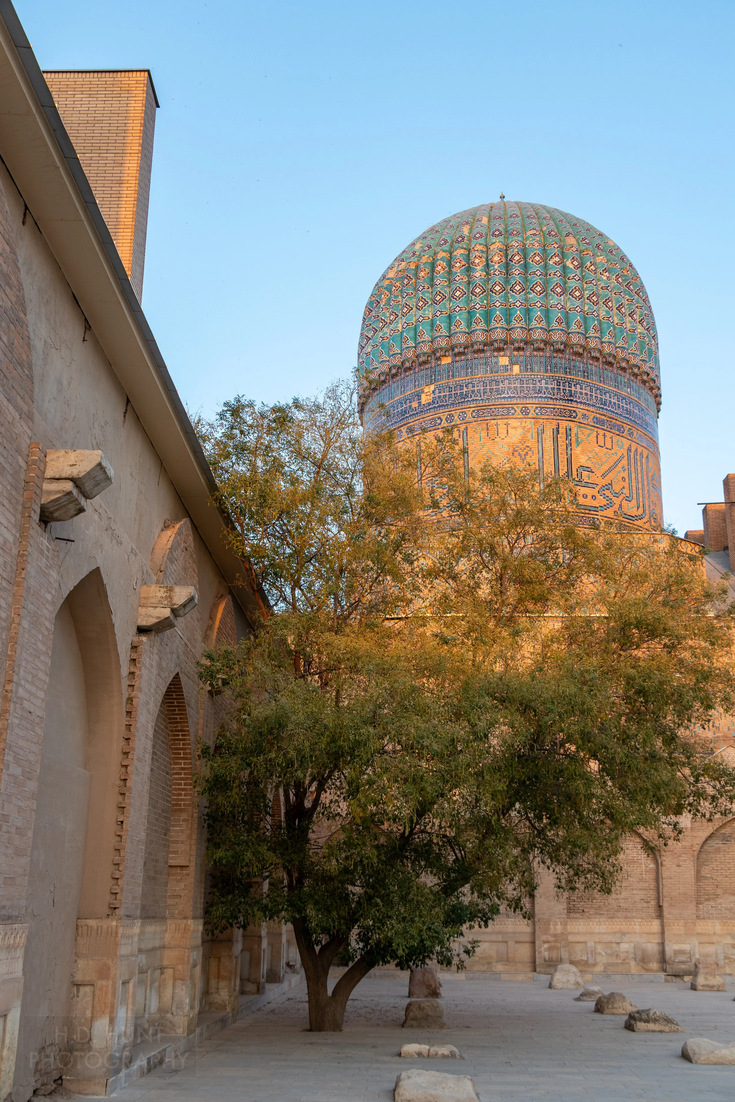An intricately-tiled blue and tan dome rises above the central courtyard of the Bibi-Khanym Mosque, Samarkand, Uzbekistan.