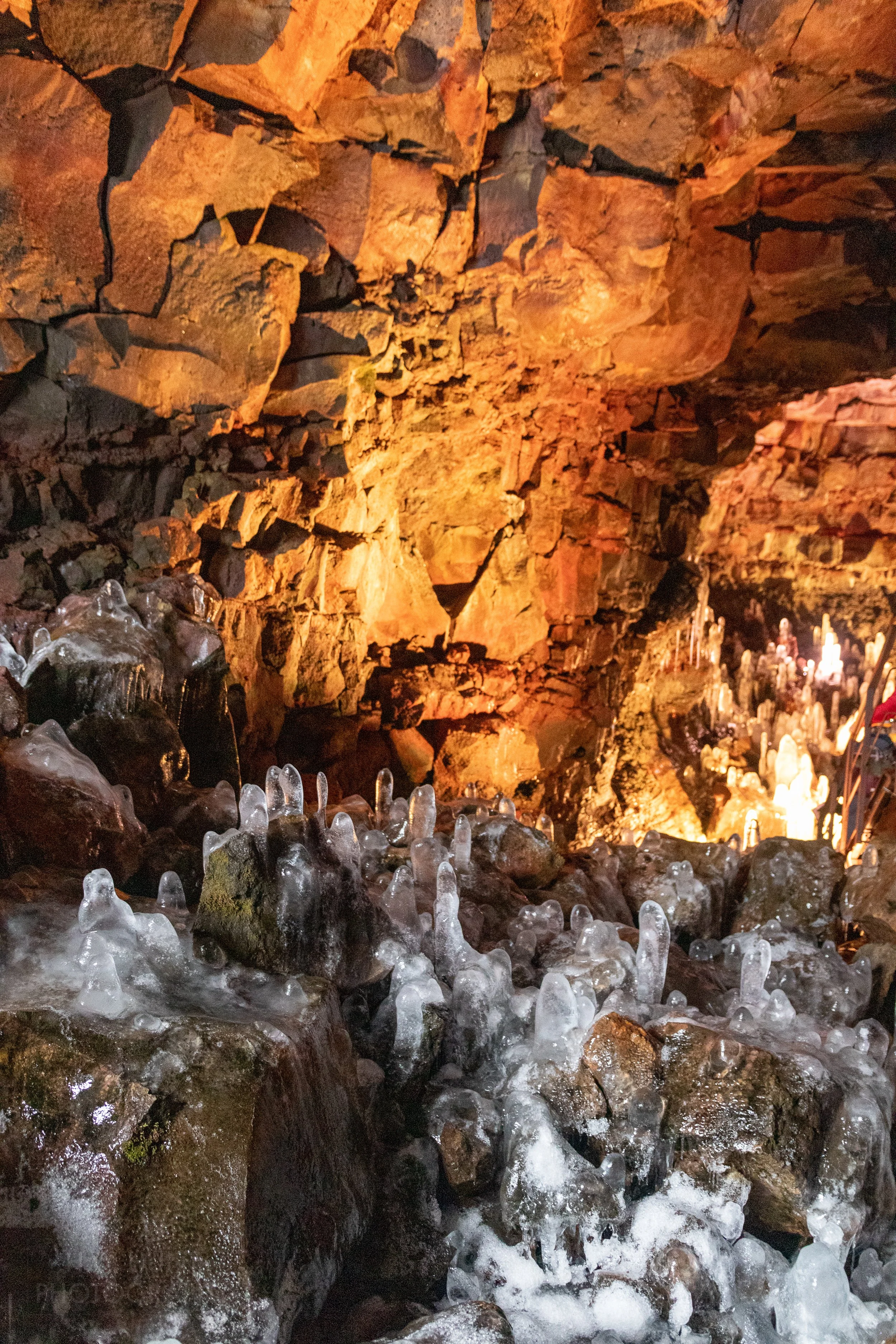 Ice columns rise from the volcanic stone floor of the lava tube Raufarhólshellir, Iceland.