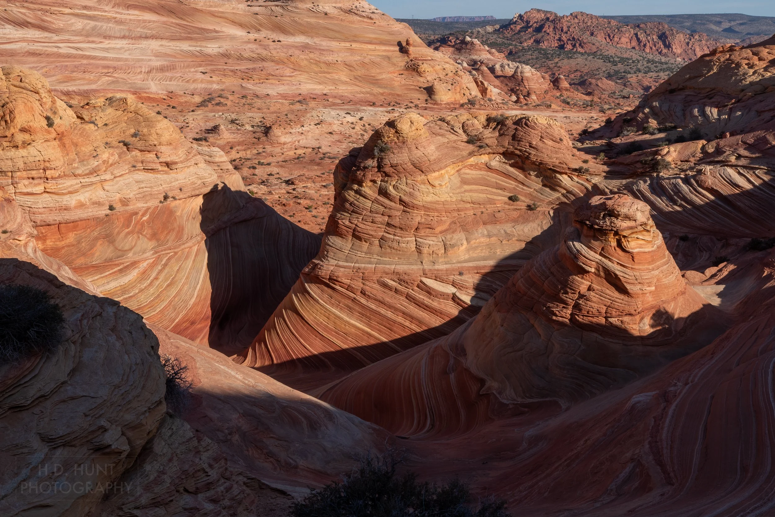 The upper portion of The Wave, a bowl-shaped sandstone rock formation, is covered in shadow in Coyote Buttes North, Paria Canyon-Vermilion Cliffs Wilderness, Arizona, United States.